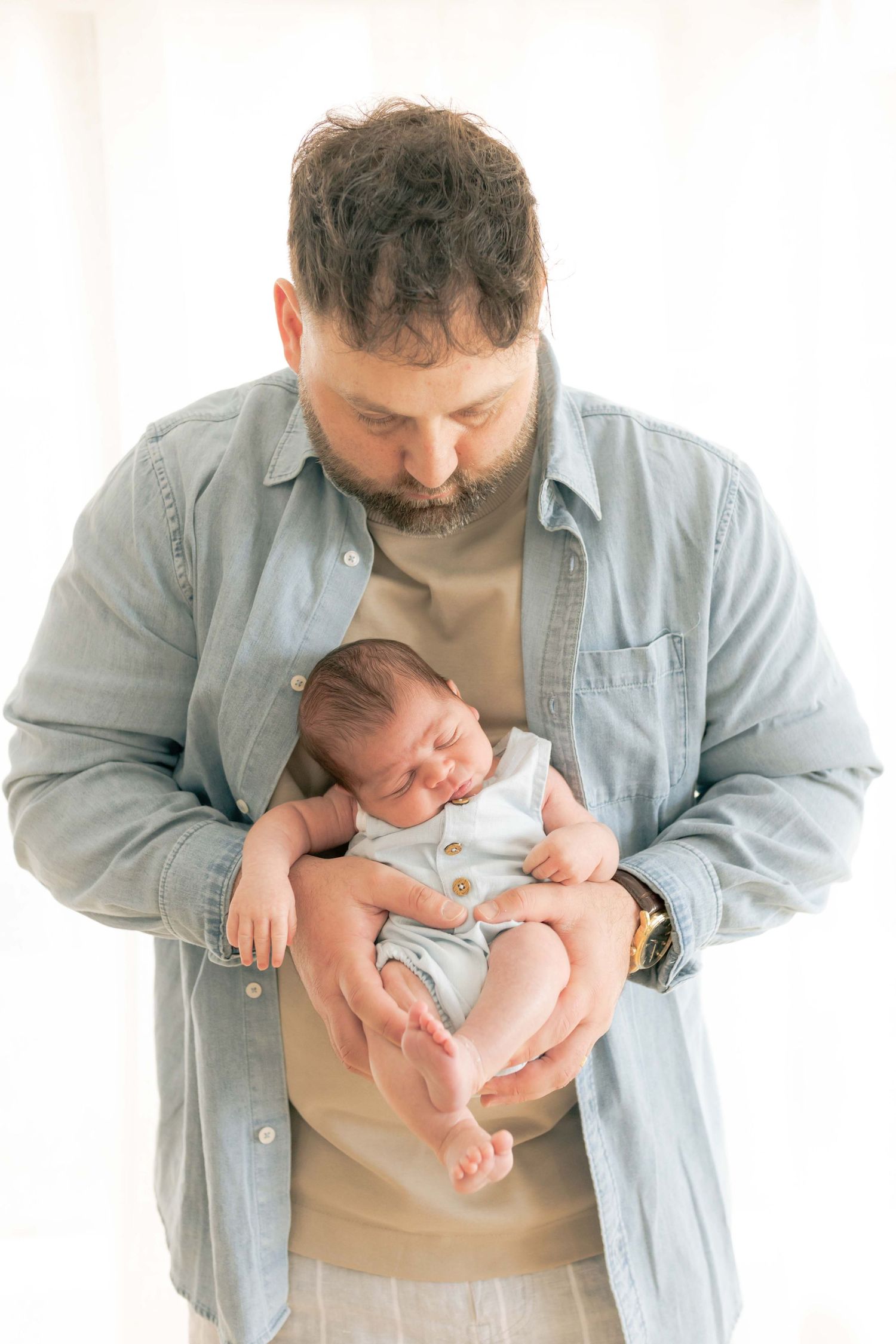 Dad holding newborn in front of him
