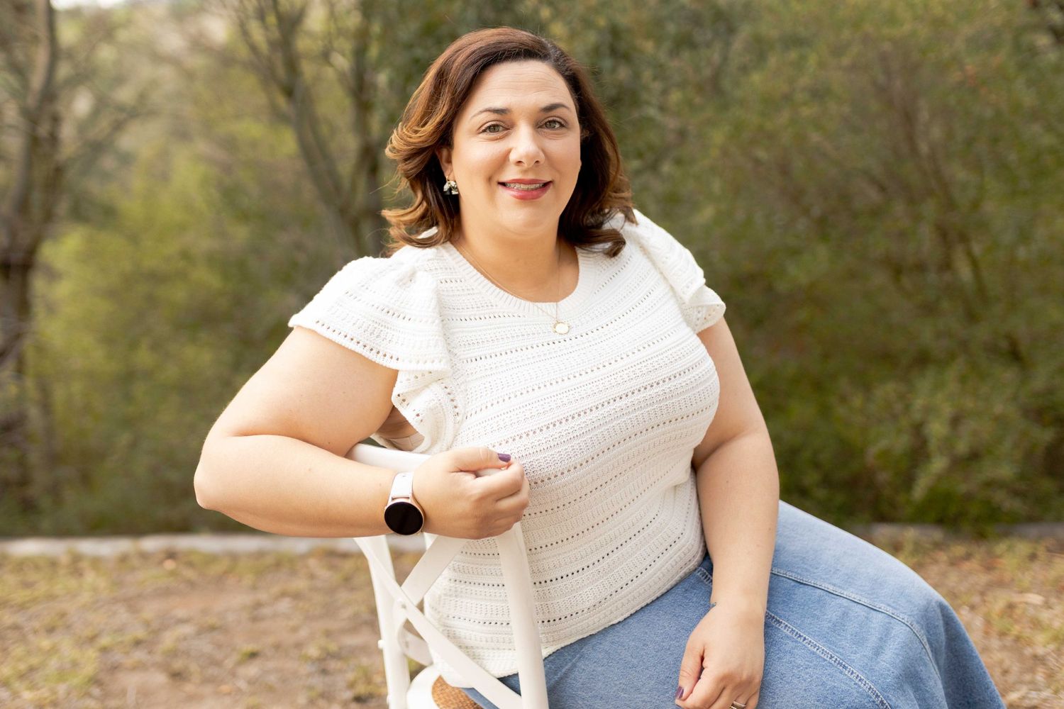 Woman sitting in a chair with bushland in the background looking at the camera photographer Sunshine North Melb Vic