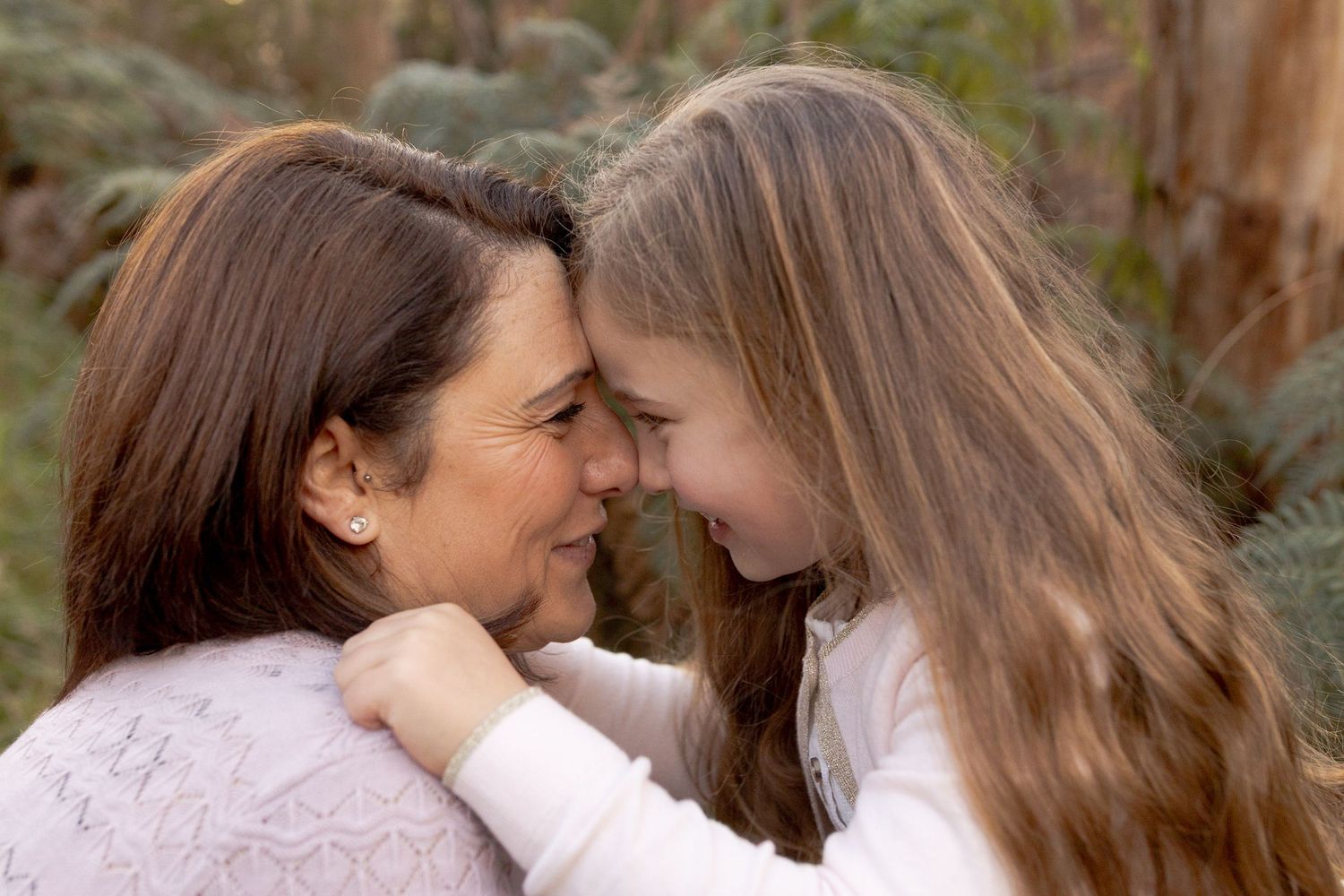 mum and daughter have their heads together smiling at each other Outdoor family session Macedon Ranges Melb