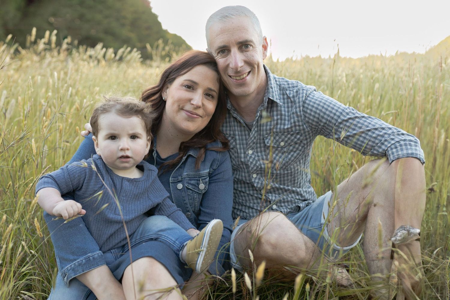 Parents and son happily looking at each other. in a field with tall grass Outdoor at home family Woodend, Melbourne, Victoria