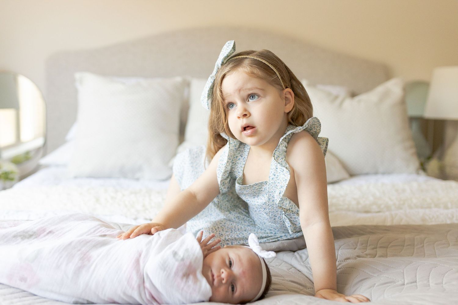 Sister holding on to newborn sister on the bed. at home newborn session Caroline Springs, Melbourne, Victoria