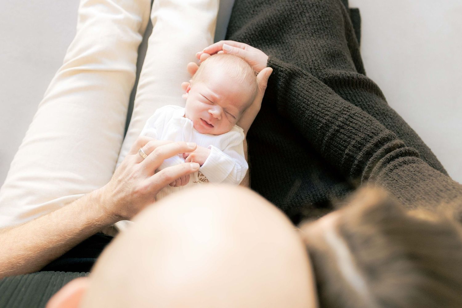 Looking down from on top of the parents head looking down at the newborn boy lying in their laps Newborn photography Melbourne's West Melton