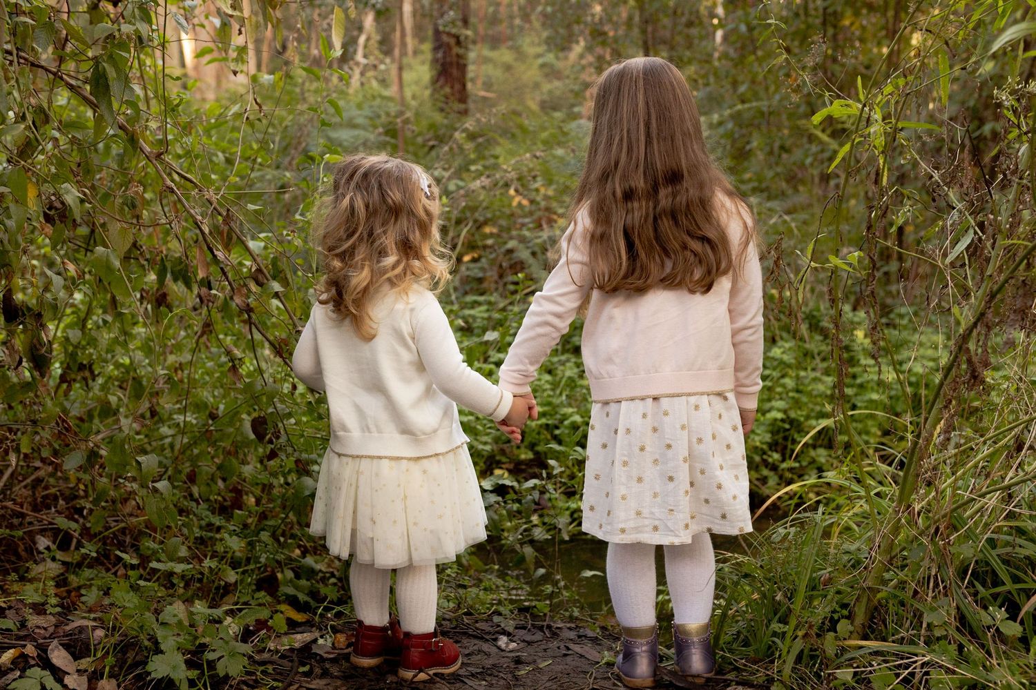 Sisters holding hands in the bushland whimsical and fairytale like outdoor family session Macedon Ranges Melb Vic