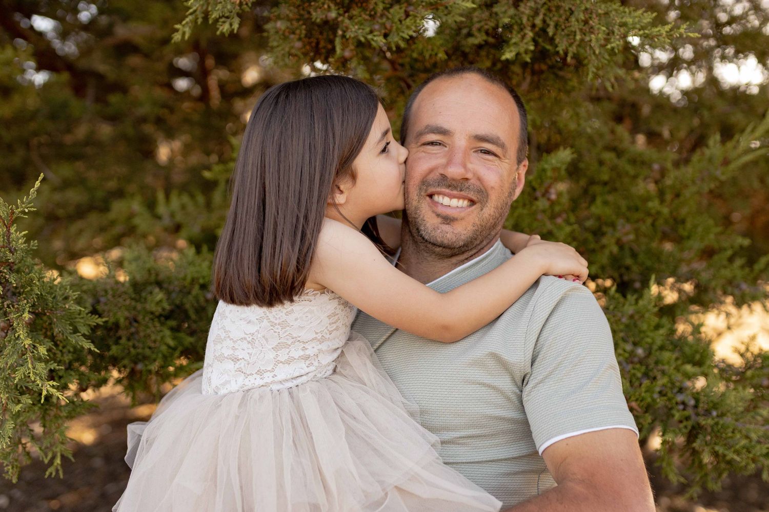 Daughter kissing her dad on the cheek Outdoor at home family session Gisborne Melb Vic