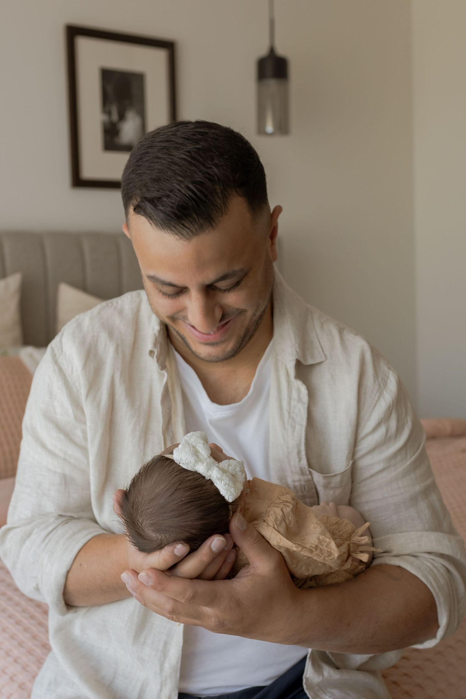 Father holding newborn daughter in front of a window at home newborn session Point Cook Melb Vic