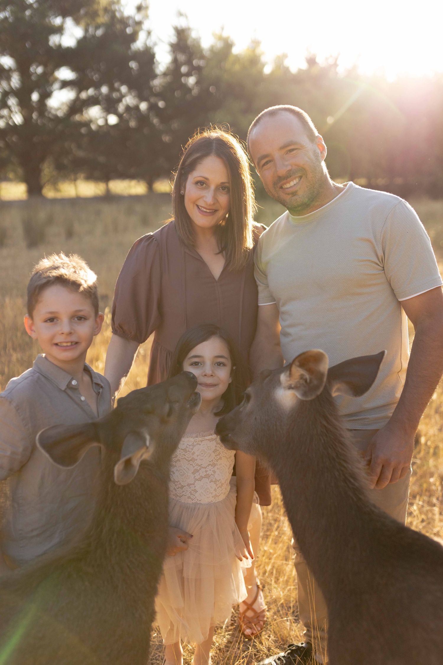 Family of four in the field standing with their pet deer Outdoor at home family session Gisborne Melb Vic