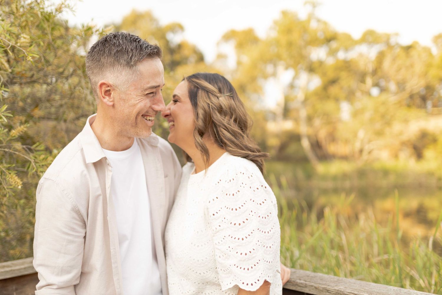 Couple sharing a laugh while hugging warm sunlight at outdoor family session, Newport Lakes Melb Vic