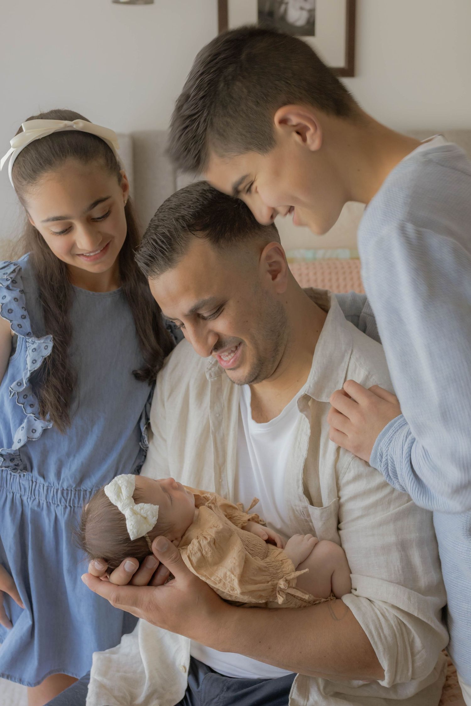 father holding the newborn baby girl older siblings looking at baby everyone hugging at home newborn session Point Cook, Melbourne, Victoria