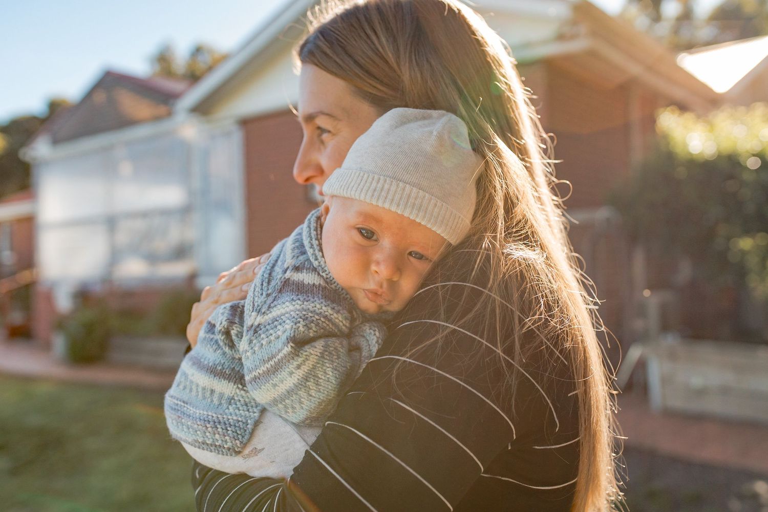 Newborn baby boy snuggled into his mothers shoulder sunlight glow, At home newborn session Gisborne Melb Vic