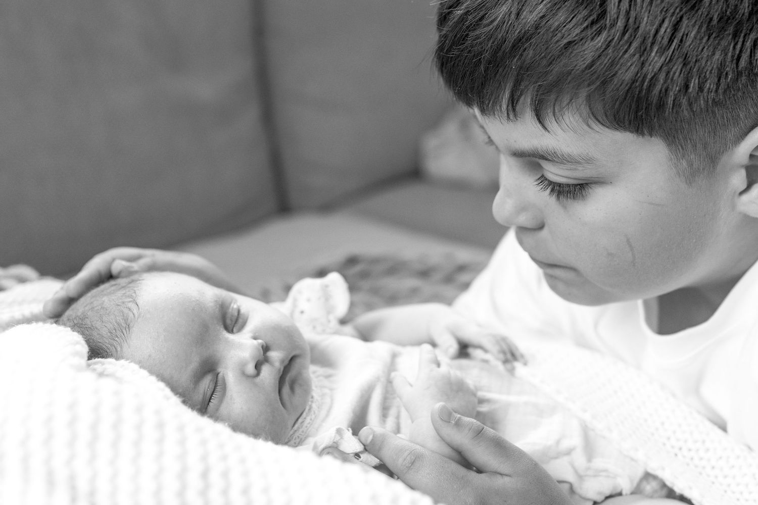 Big brother looking at his baby sister