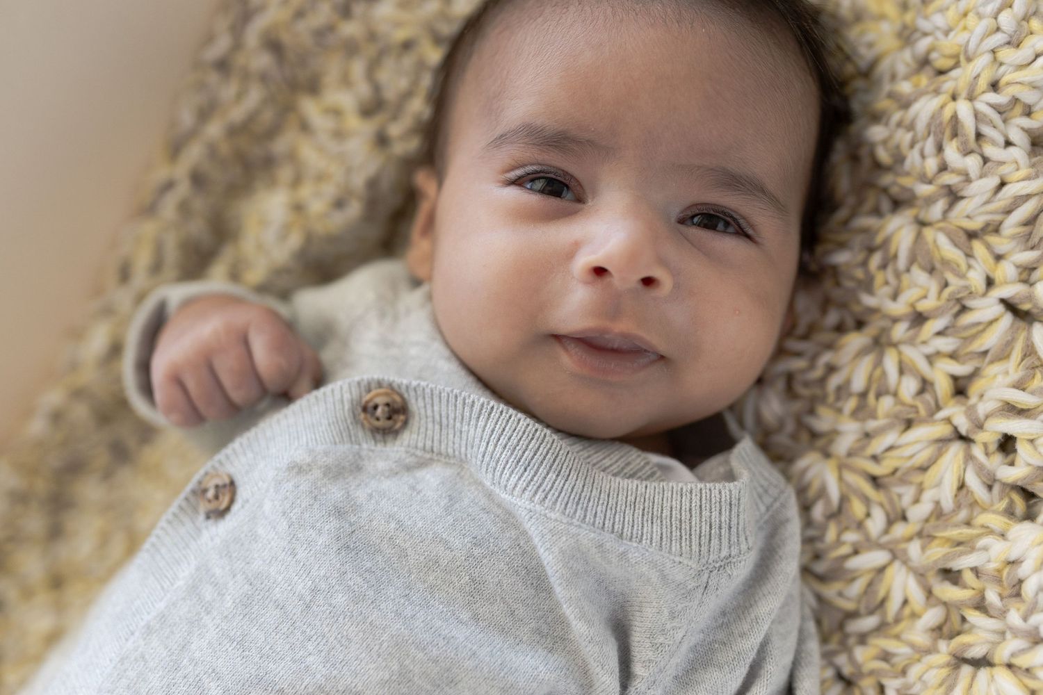 baby boy in basinet with little grin At home family session, sunshine north melb vic