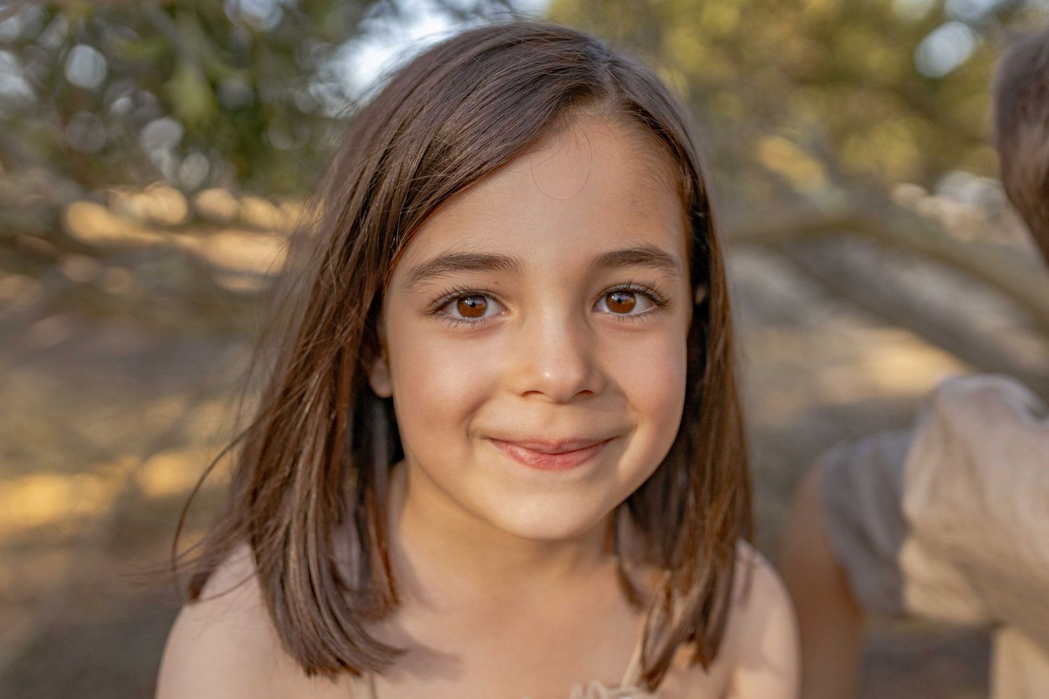 Little girl looking at the camera and smiling Outdoor at home family session Gisborne Melb Vic