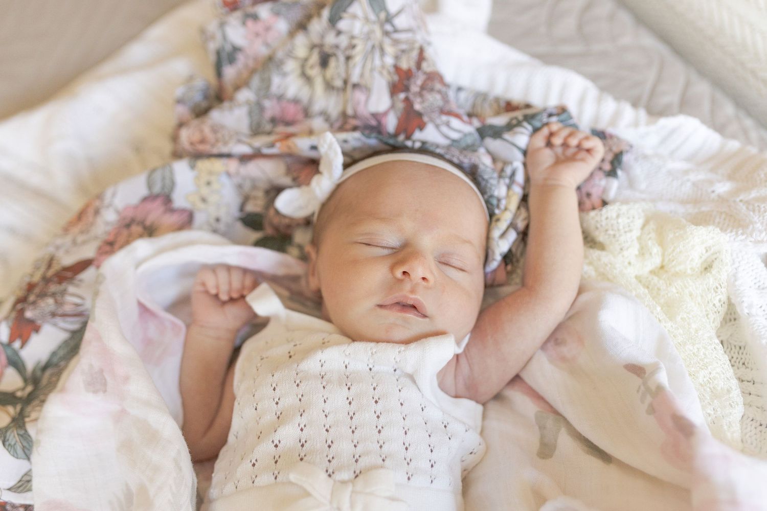 Newborn baby girl sleeping on the bed with floral swaddles at home newborn session, Caroline Springs Melb, Vic