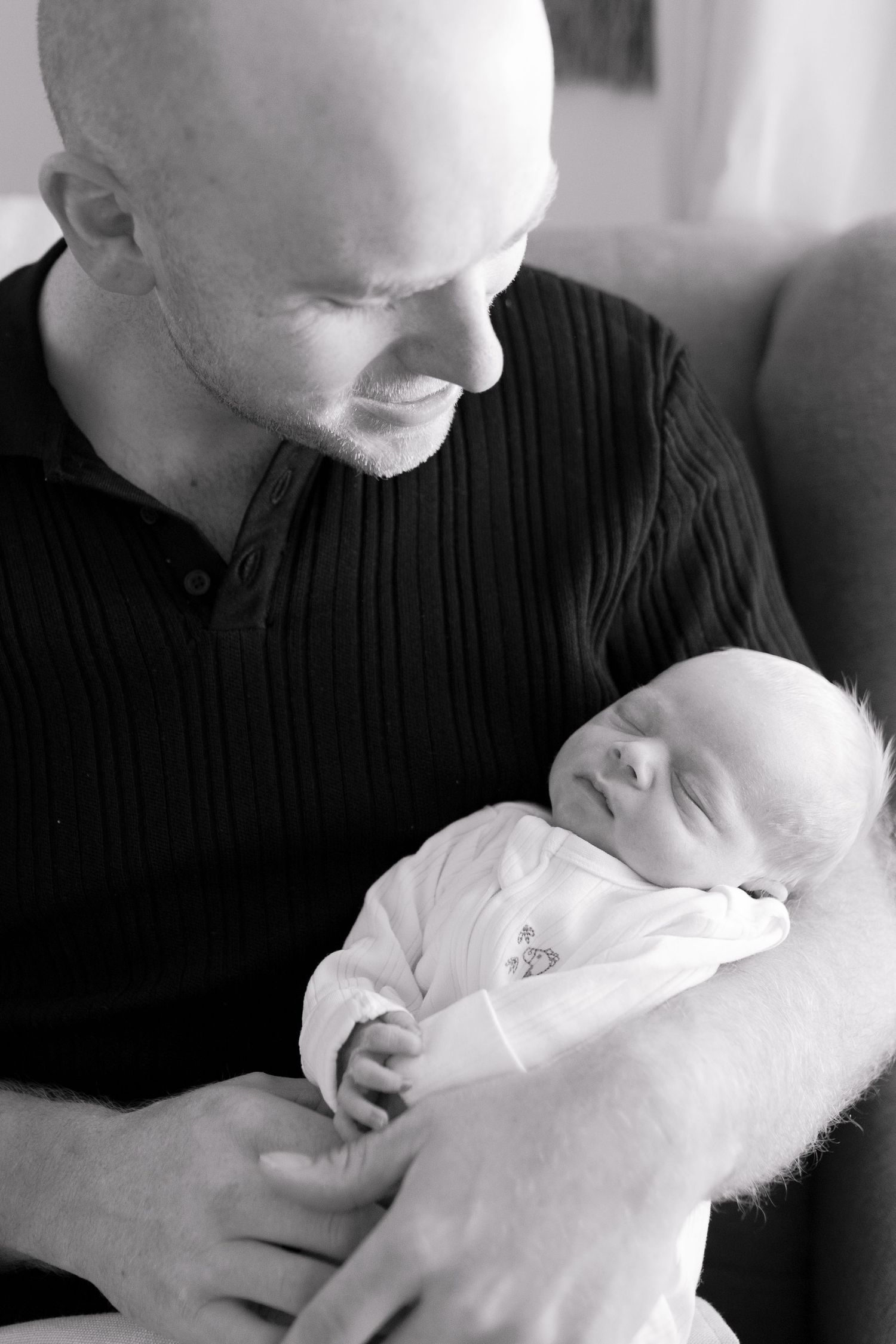 Dad looking down at his newborn son smiling Melbourne's west newborn photography