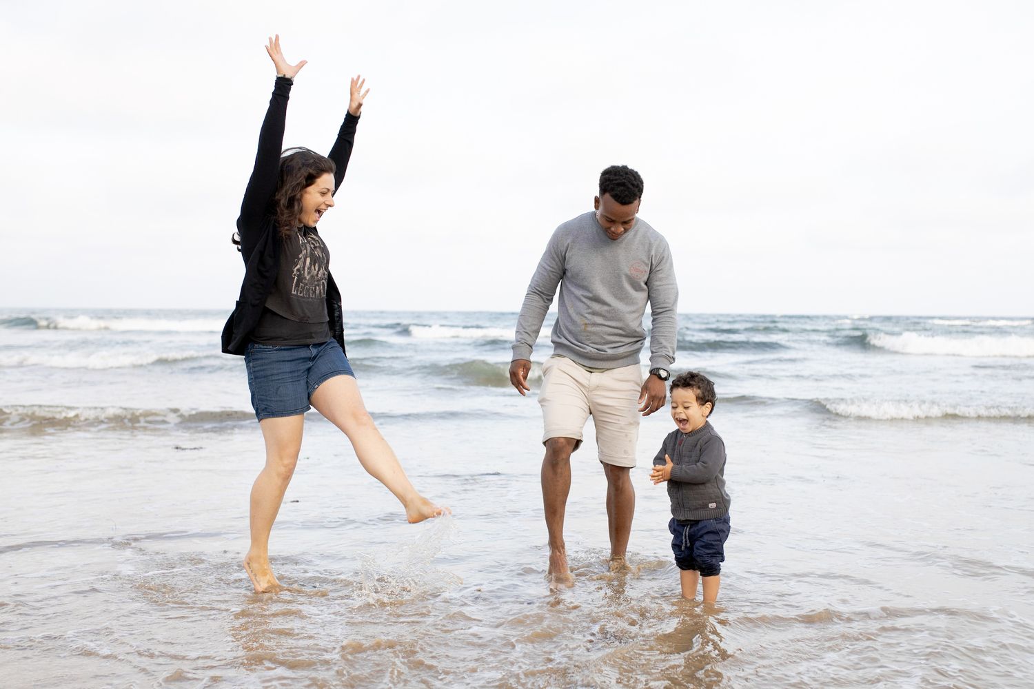 Family of three splashing at the beach Outdoor family session Torquay