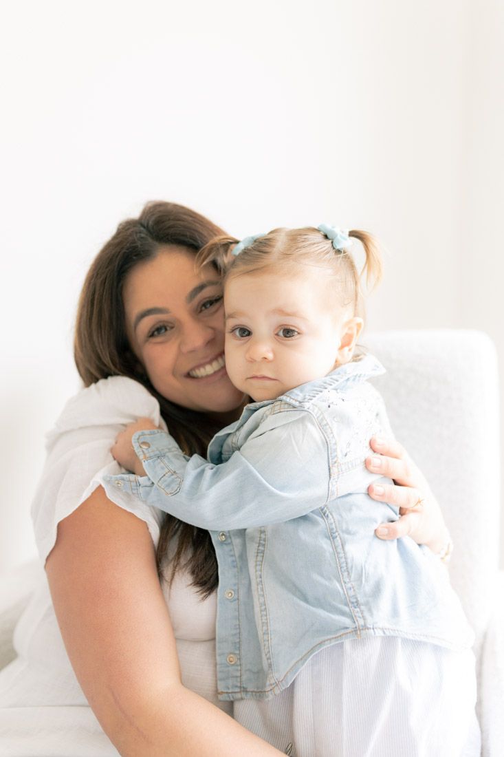 Mum smiling while holding daughter closely Burnside