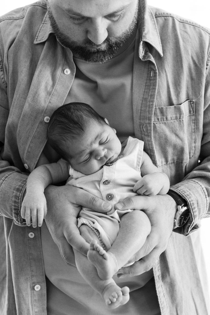 Dad holding newborn in front of him