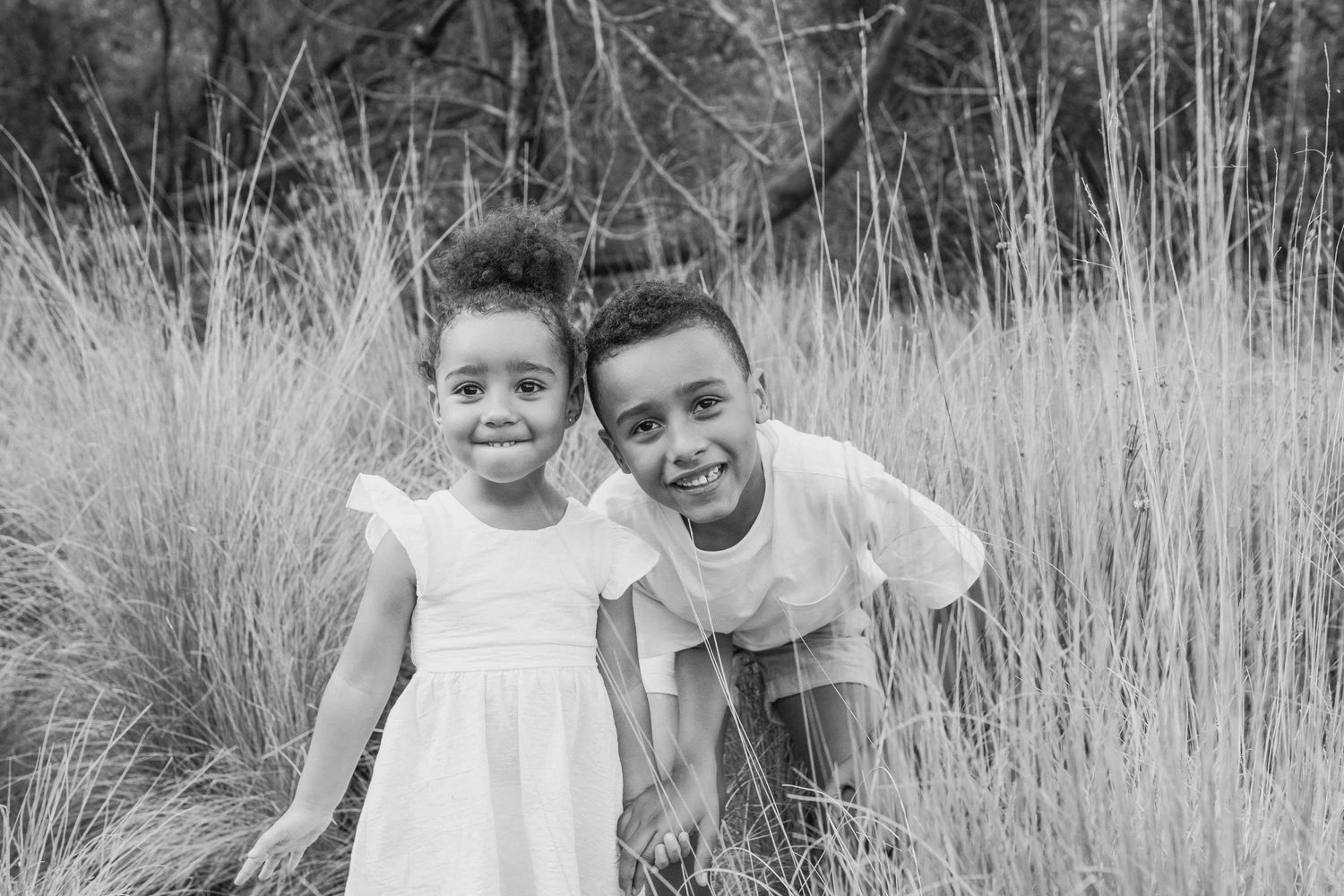 Siblings smiling close together family outdoor session in the tall grass, Newport Lakes Melb Vic