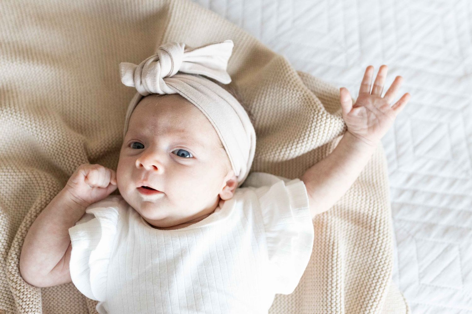 Newborn baby girl stretched out on the bed big bow. Little sister, family of four. Tullamarine