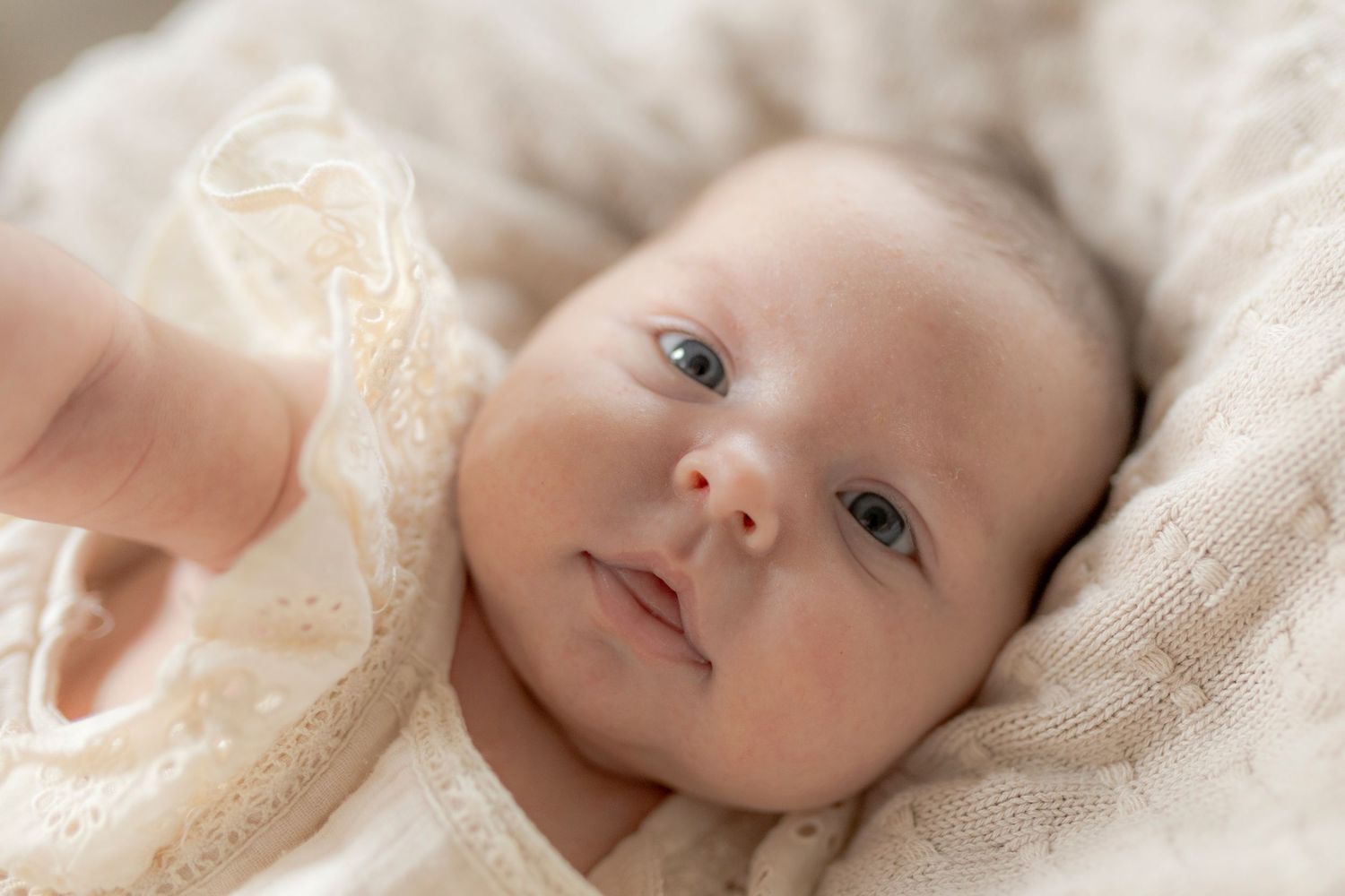 Newborn baby girl reaching for the camera