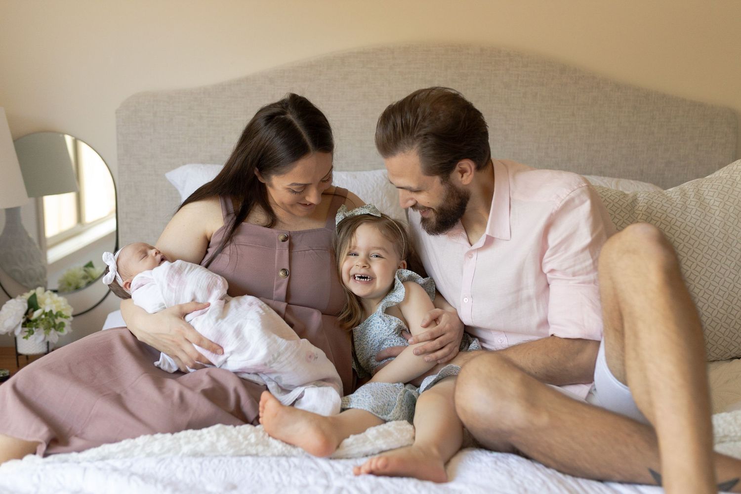 Newborn at home session family of four lying on the bed hugging with baby girl. Caroline Springs, Melb, Vic