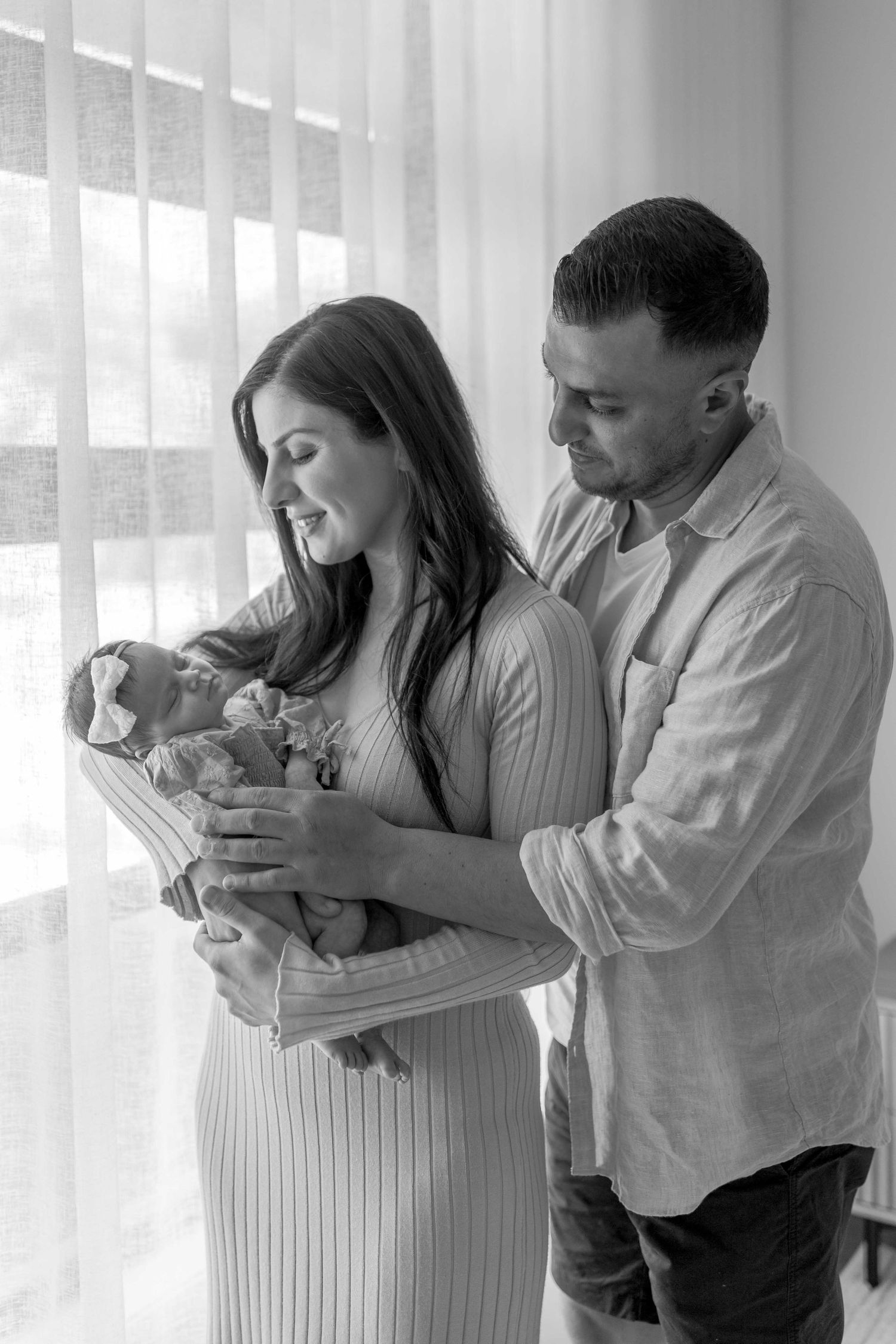 Parents standing in their bedroom holding their baby girl hugging each other, Point Cook, Melb, Vic