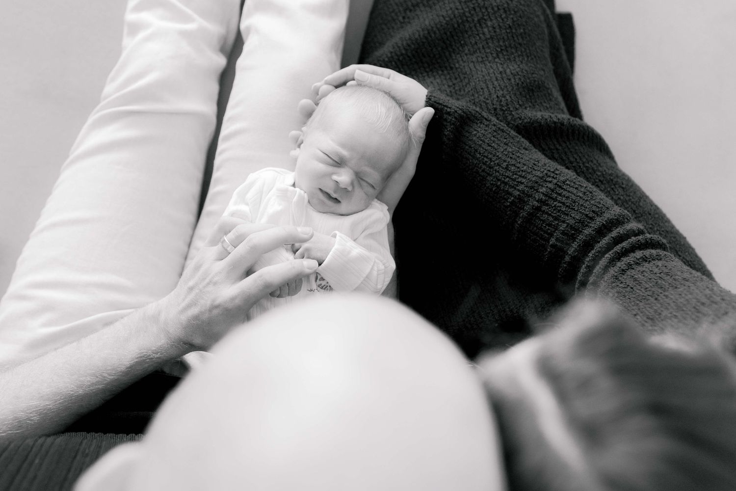 Looking down from on top of the parents head looking down at the newborn boy lying in their laps Newborn photography Melbourne's West Melton