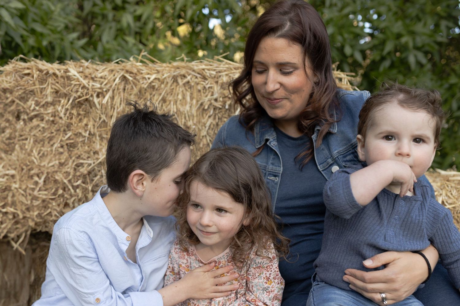 Mother with children siblings whispering to each other outdoor at home family session. Woodend, Melb Vic