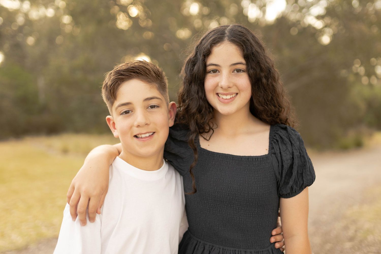 Siblings big sister and younger brother smiling hugging outdoor family session Newport, Melbourne, Victoria