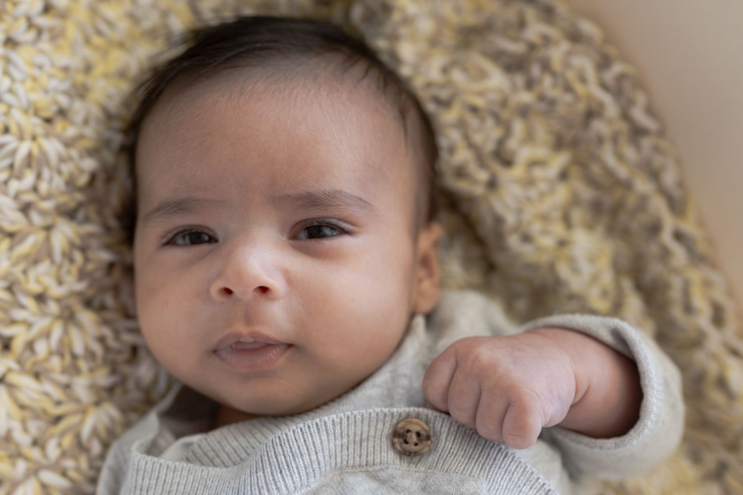 baby boy in basinet with little grin At home family session, sunshine north melb vic