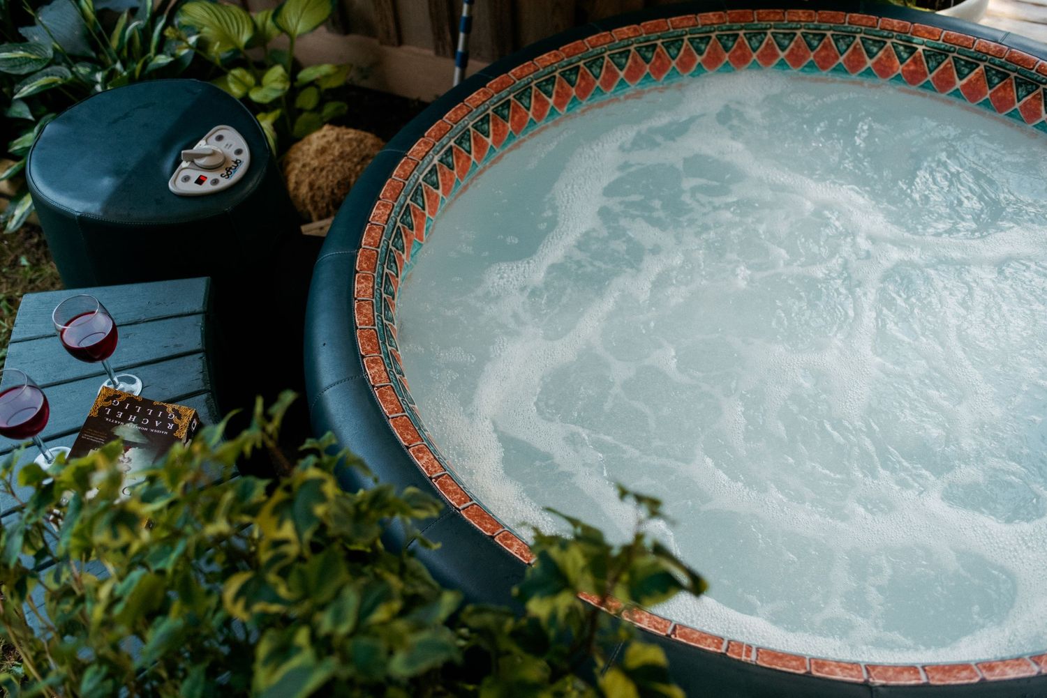 open hot tub with wine glasses at wild plum cottage
