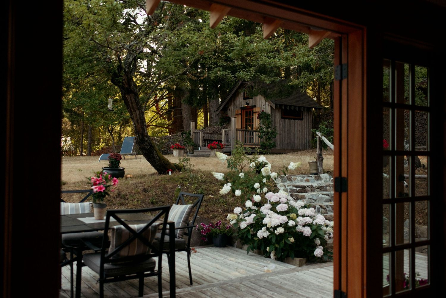 view of the bunkie at sacred arrow estates through the back doors of the wild plum cottage