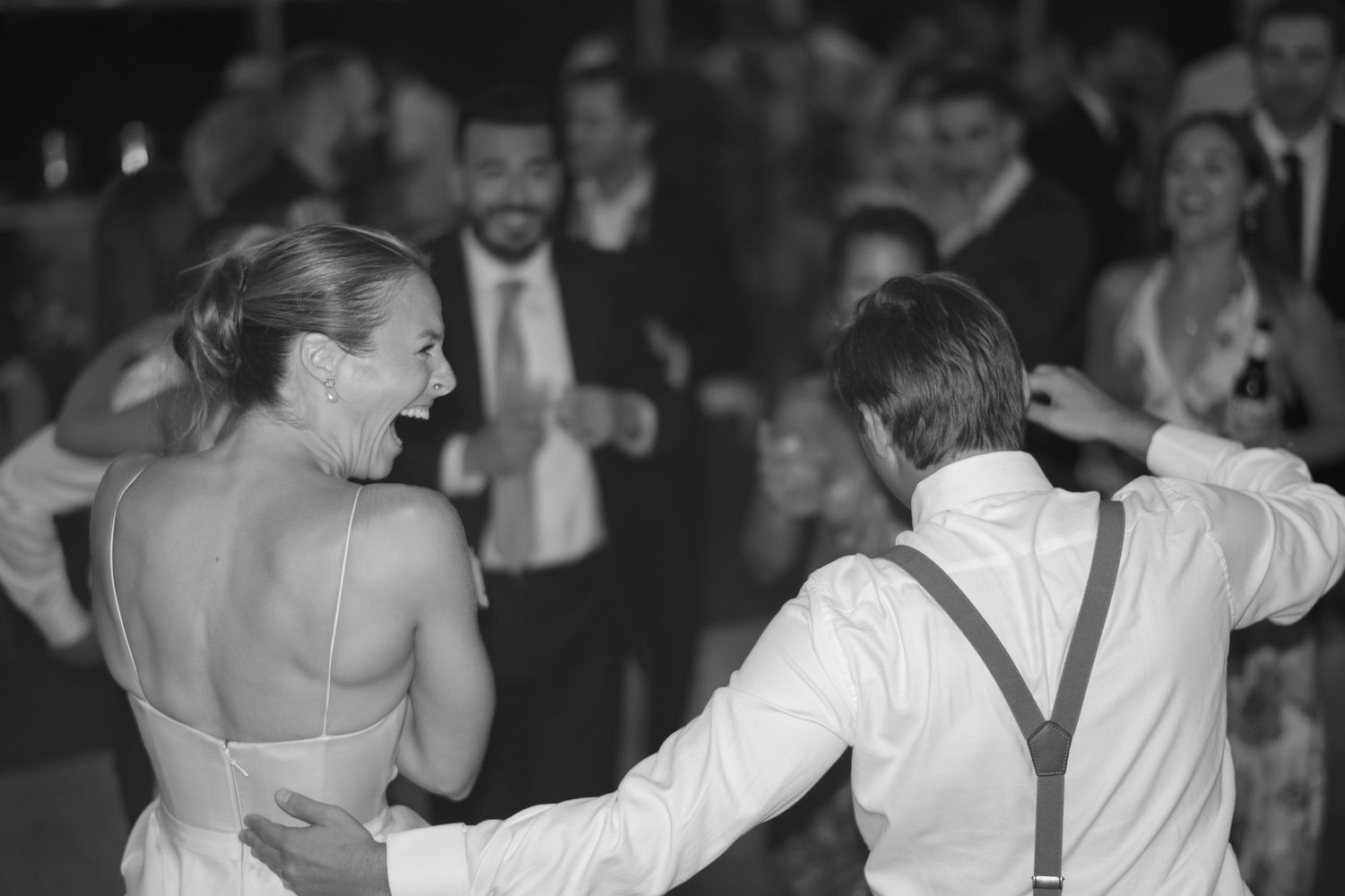 Bride and groom sharing first dance at wedding reception in black and white photo.