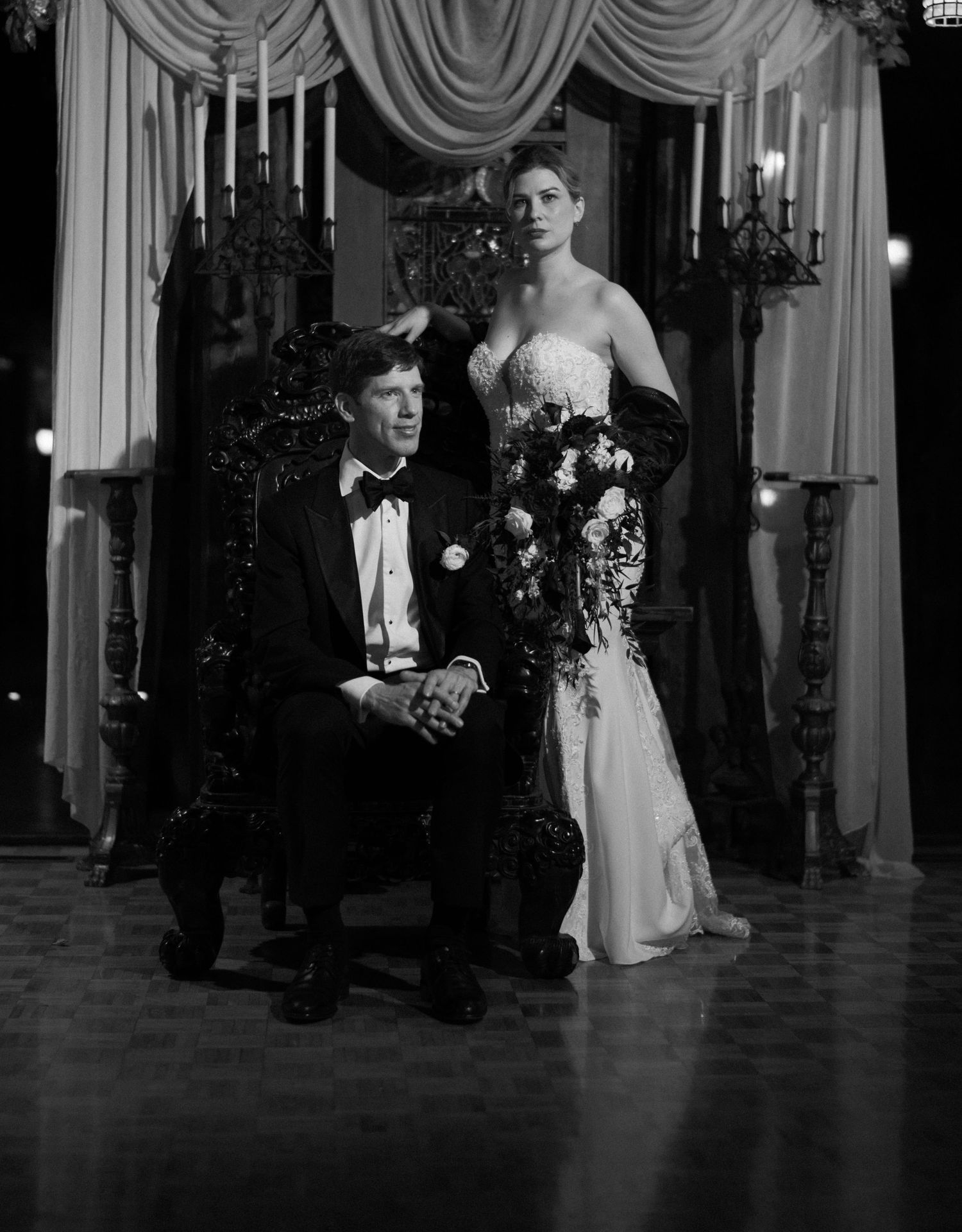 A formal portrait in classic Hollywood style with elegant draping and candelabras in the background.