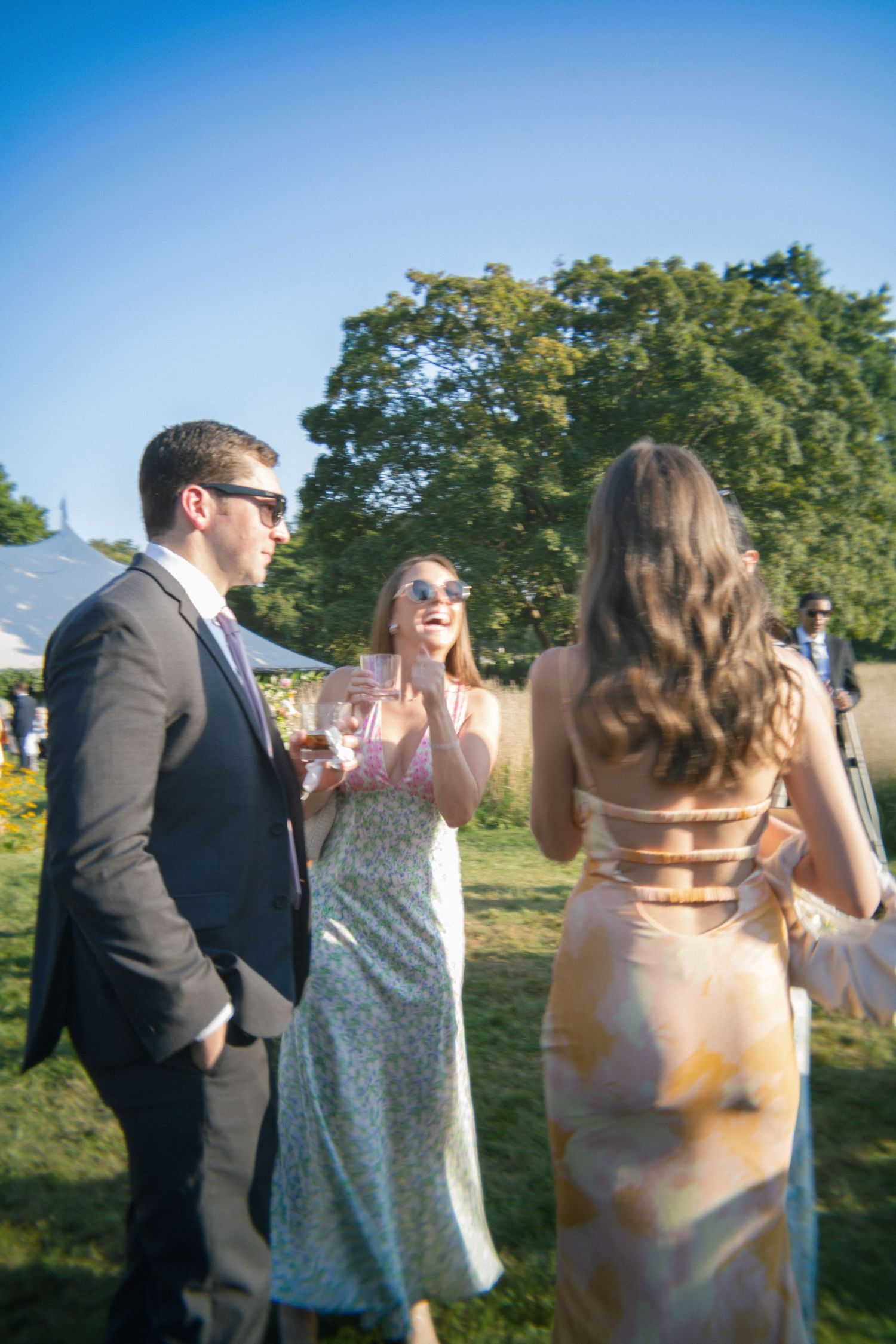 Wedding guests enjoying conversation during an outdoor summer reception.
