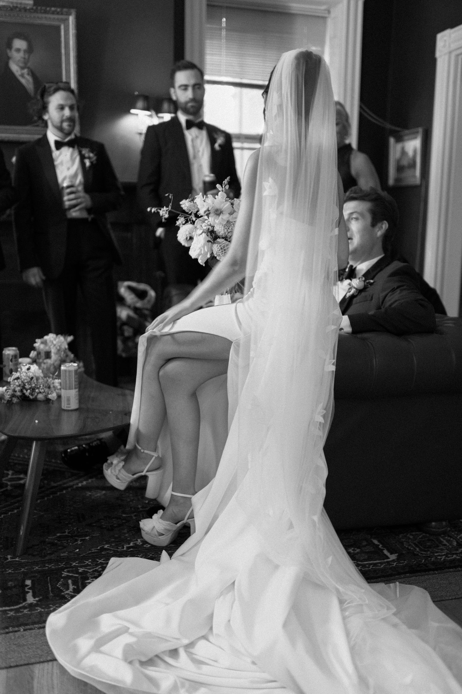 Elegant bridal setting with flowing white dress and veil against dark interior decor.