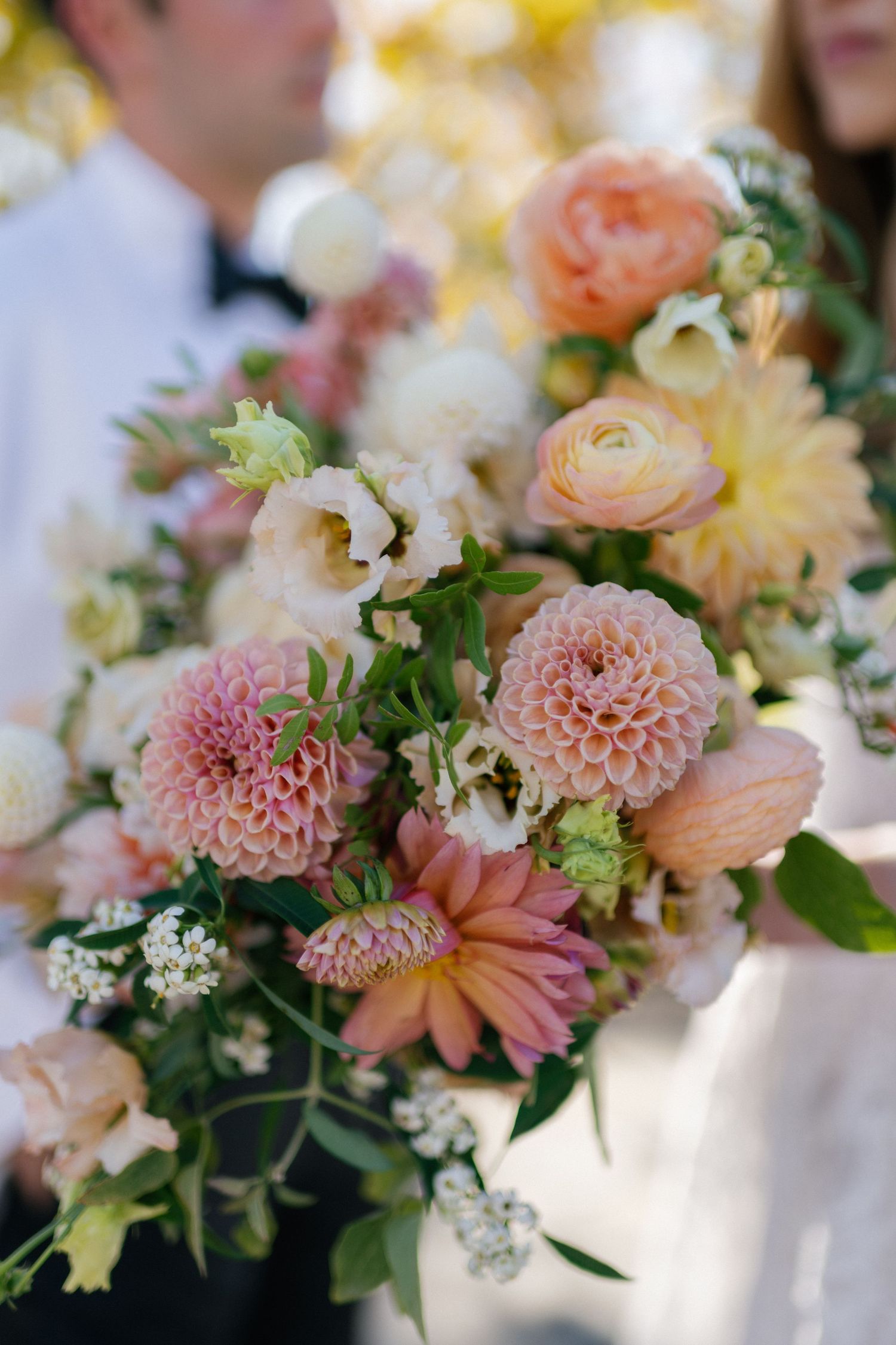 Close-up of romantic pastel wedding bouquet with dahlias, roses and delicate flowers.