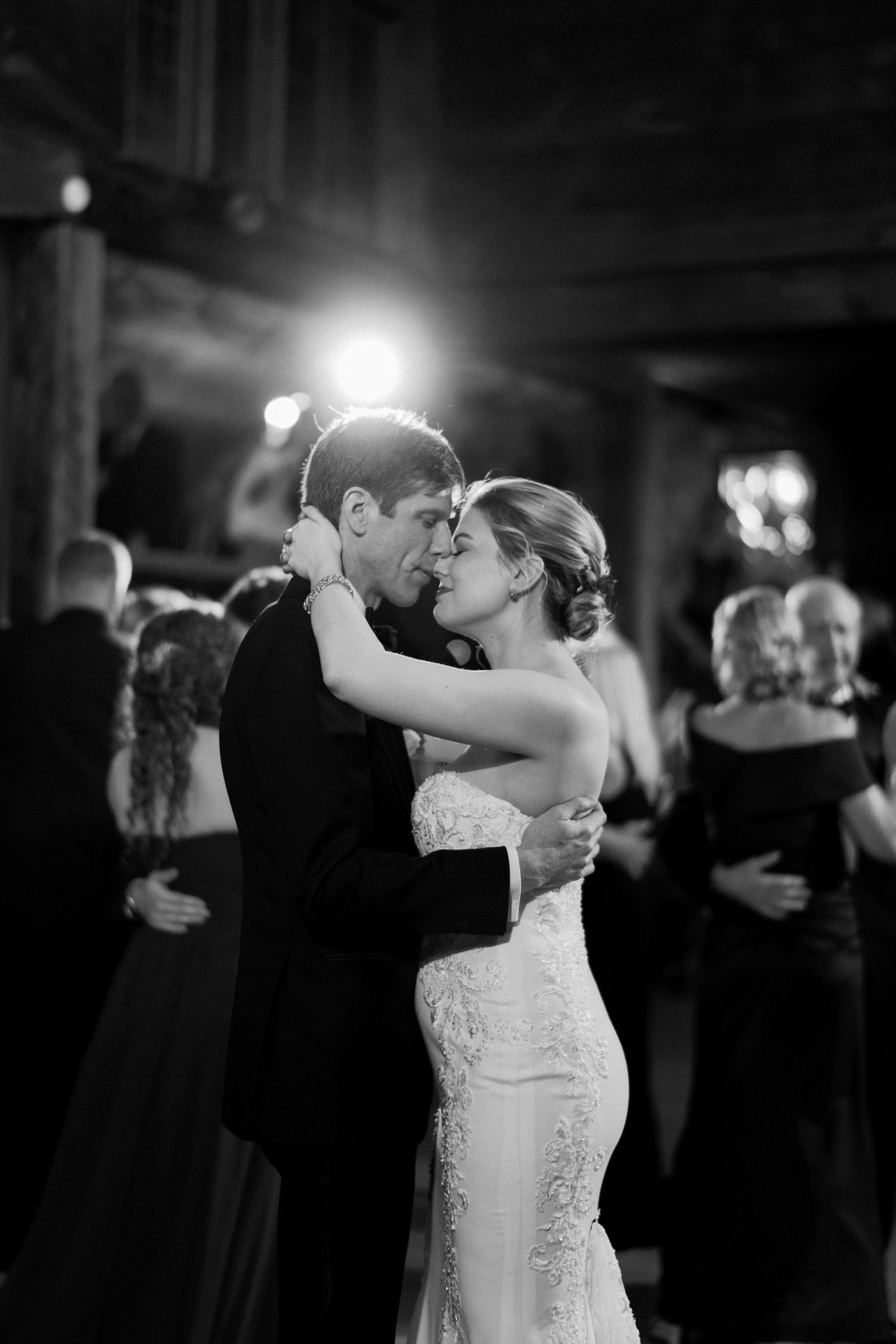 A romantic black and white photo of a couple's first dance at their wedding reception.
