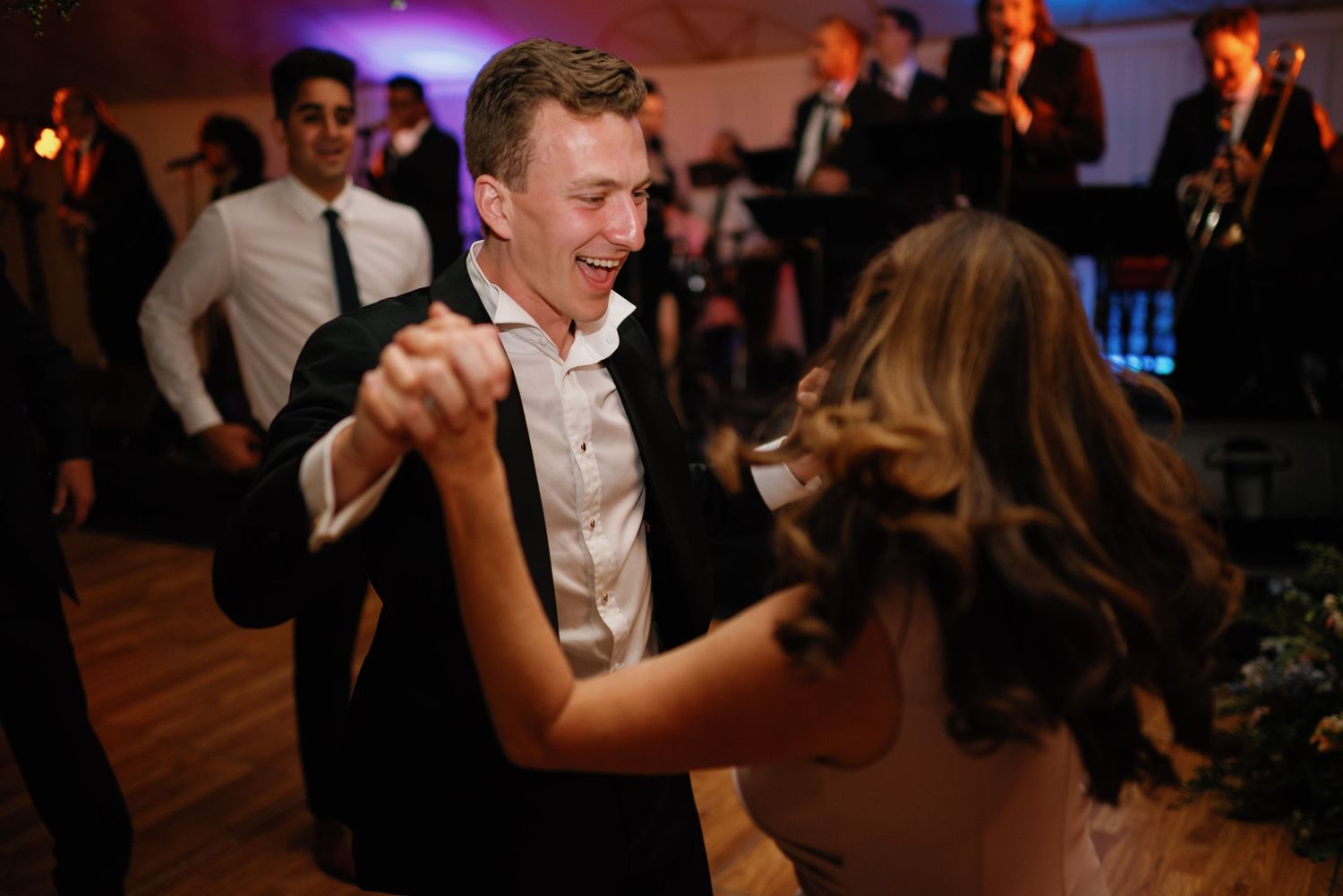 Couples dancing together at an elegant evening wedding reception with warm ambient lighting.
