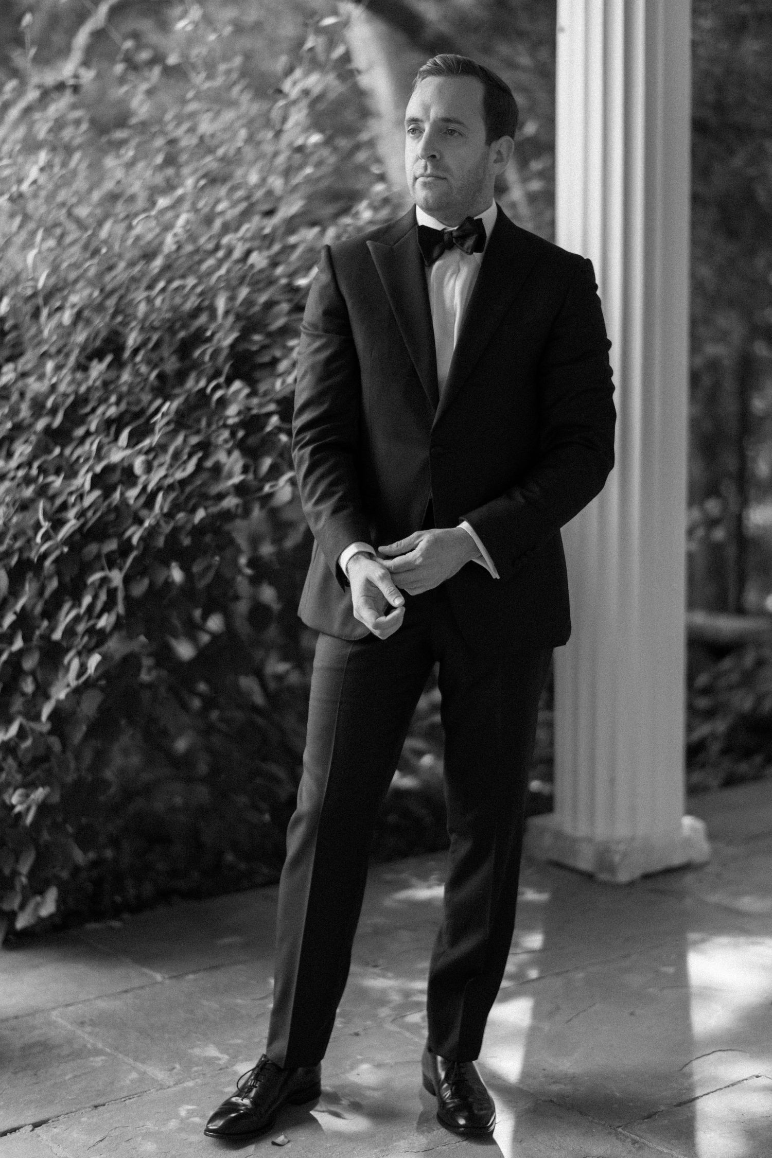 Black and white photo sequence showing someone in a suit performing dramatic bending and leaning poses against a column.