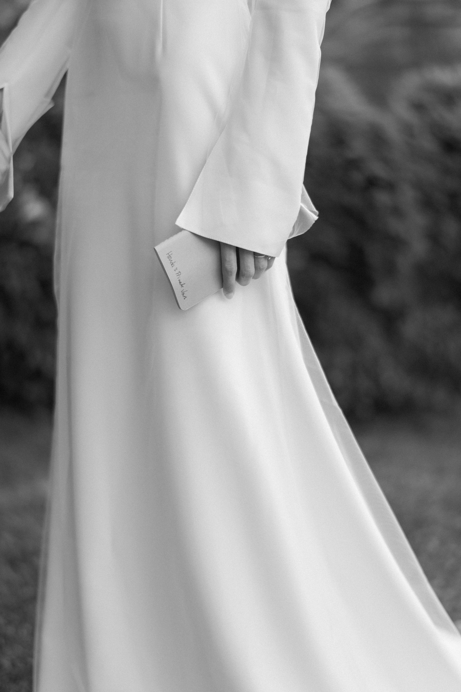 Close-up detail of elegant white wedding dress fabric and sleeve.