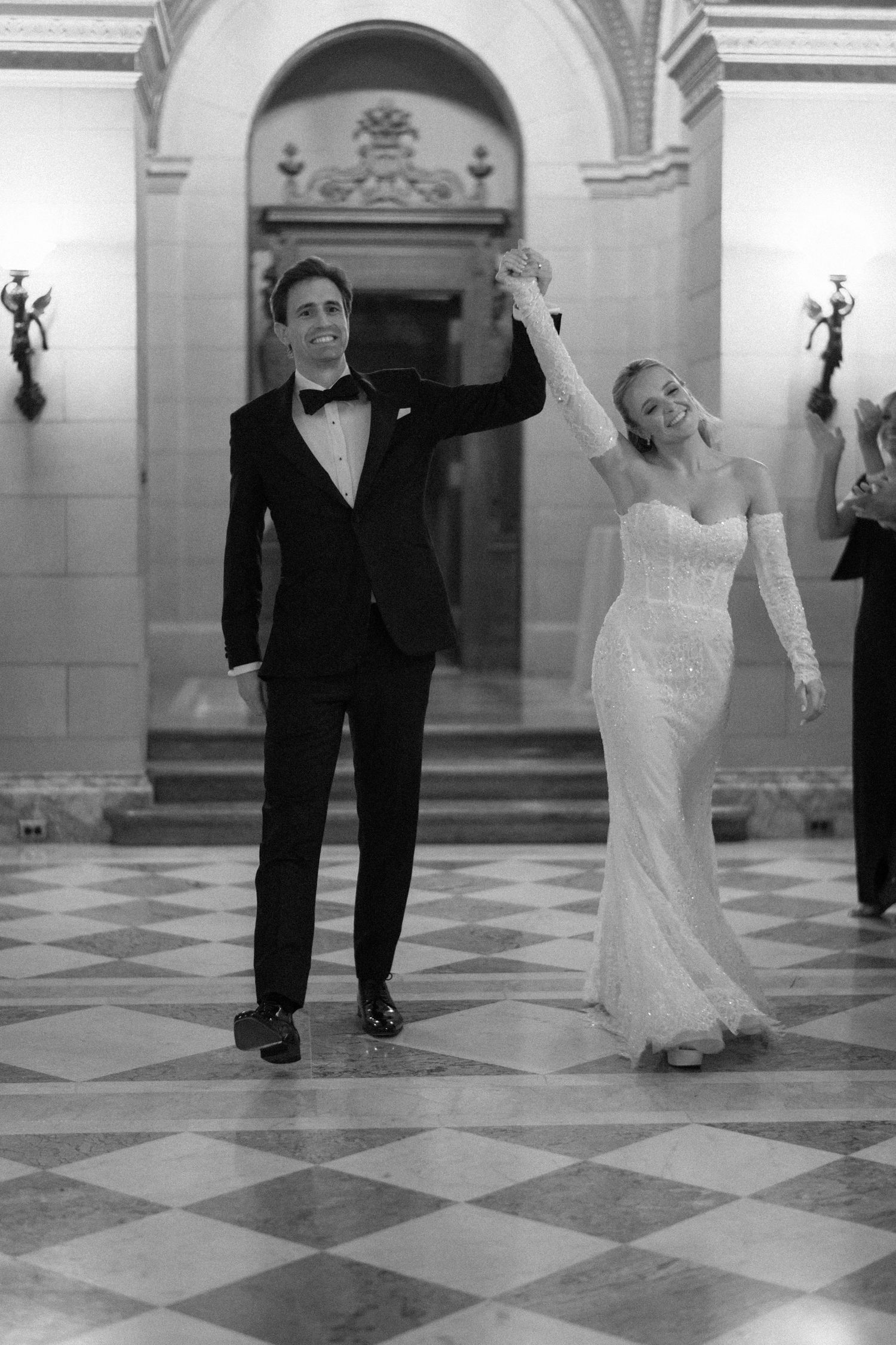 Black and white sequence of four images showing a couple dancing together on a checkered floor in a grand hall.