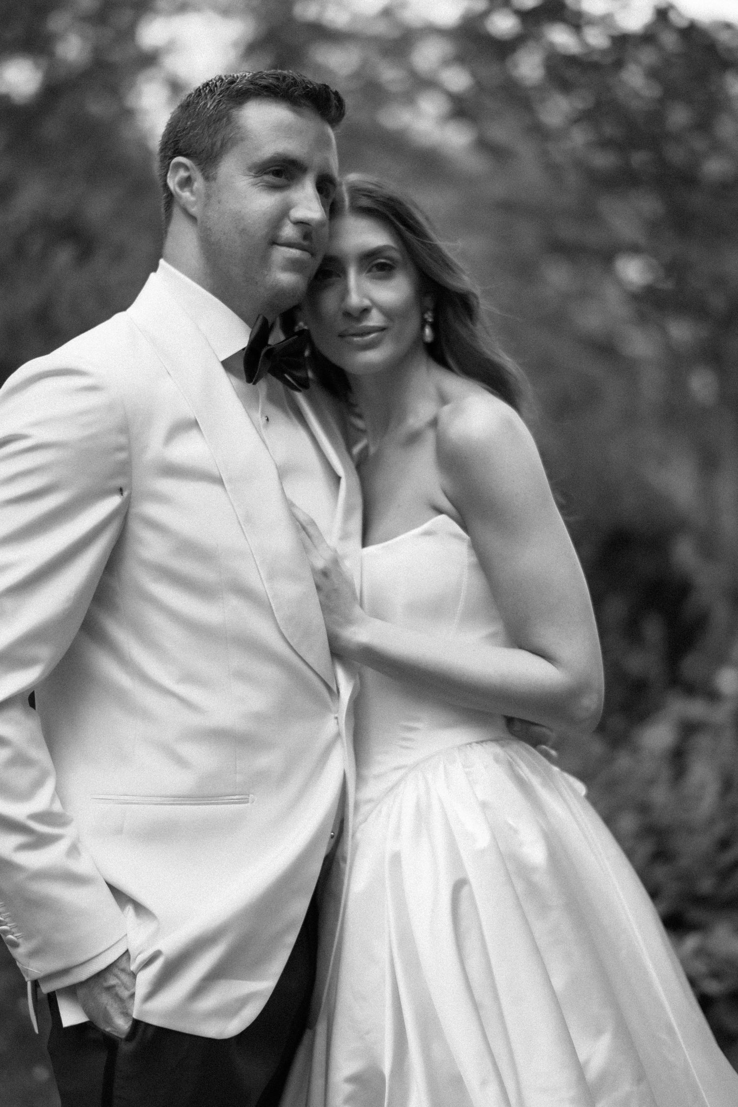 A romantic black and white photo series showing a couple in wedding attire sharing intimate moments outdoors.