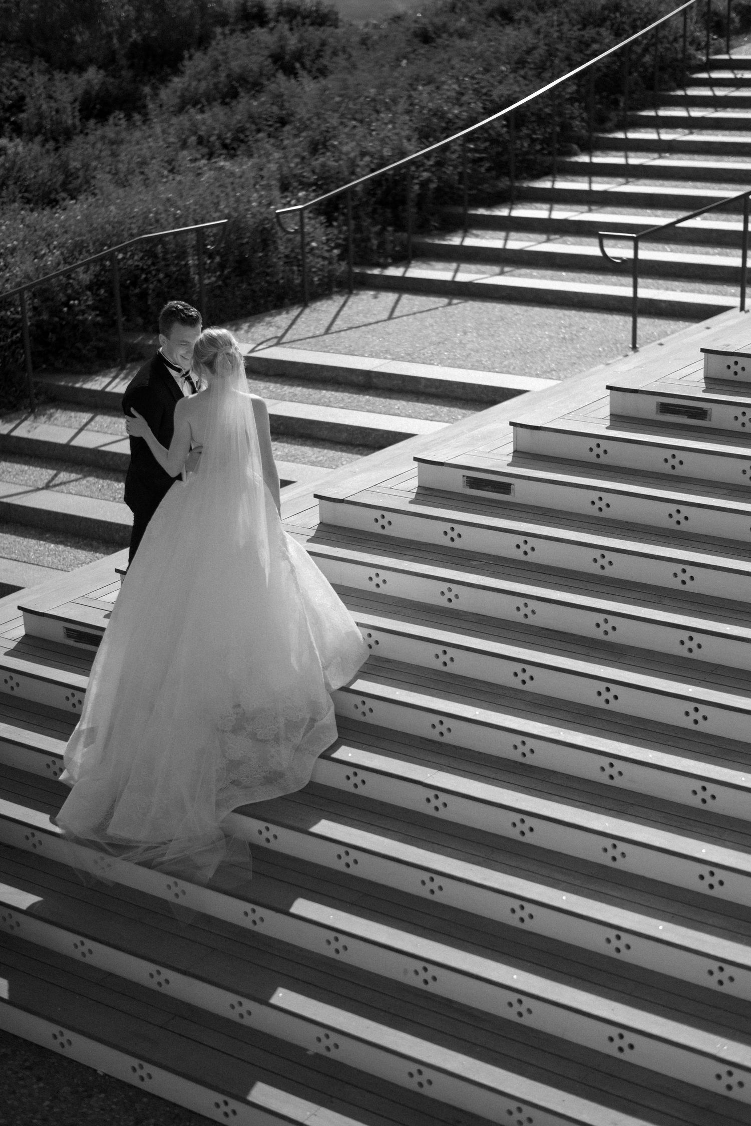 A sequence of black and white photos showing a person in a flowing white dress ascending outdoor stone steps.