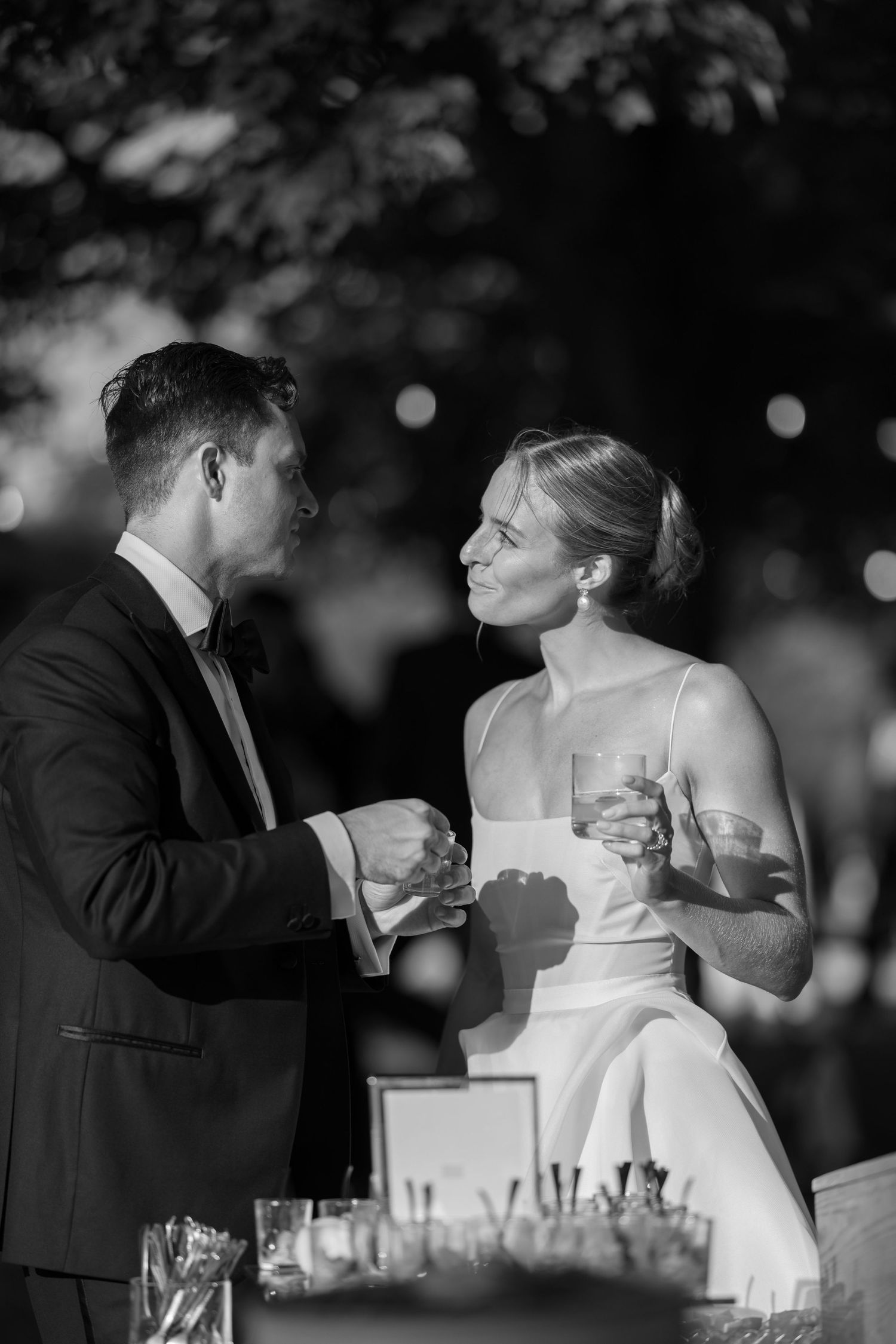 Black and white wedding sequence shows couple sharing romantic champagne toast in four candid moments.