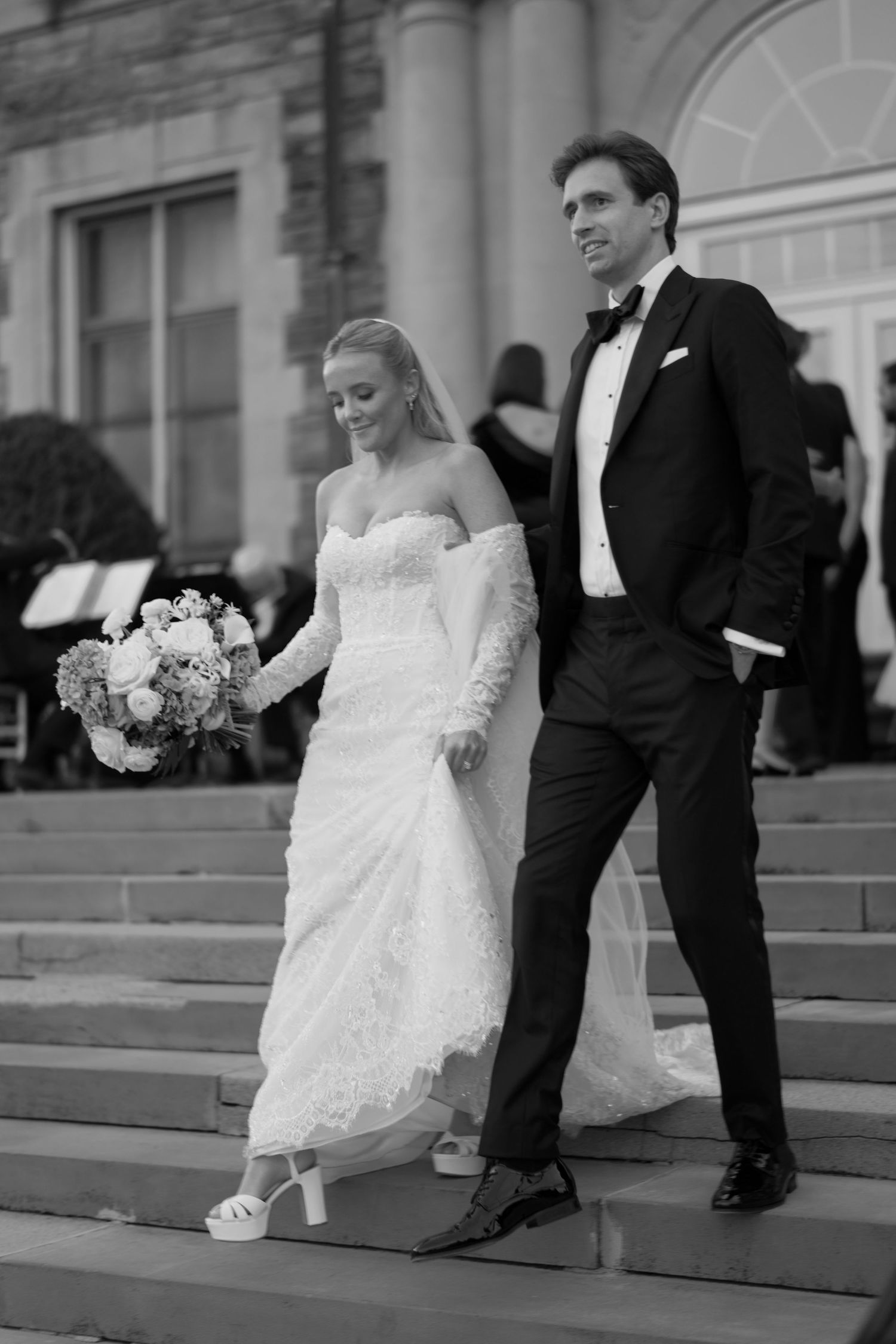 A bride and groom sit on stone steps showing their formal wedding shoes in a series of black and white photos.