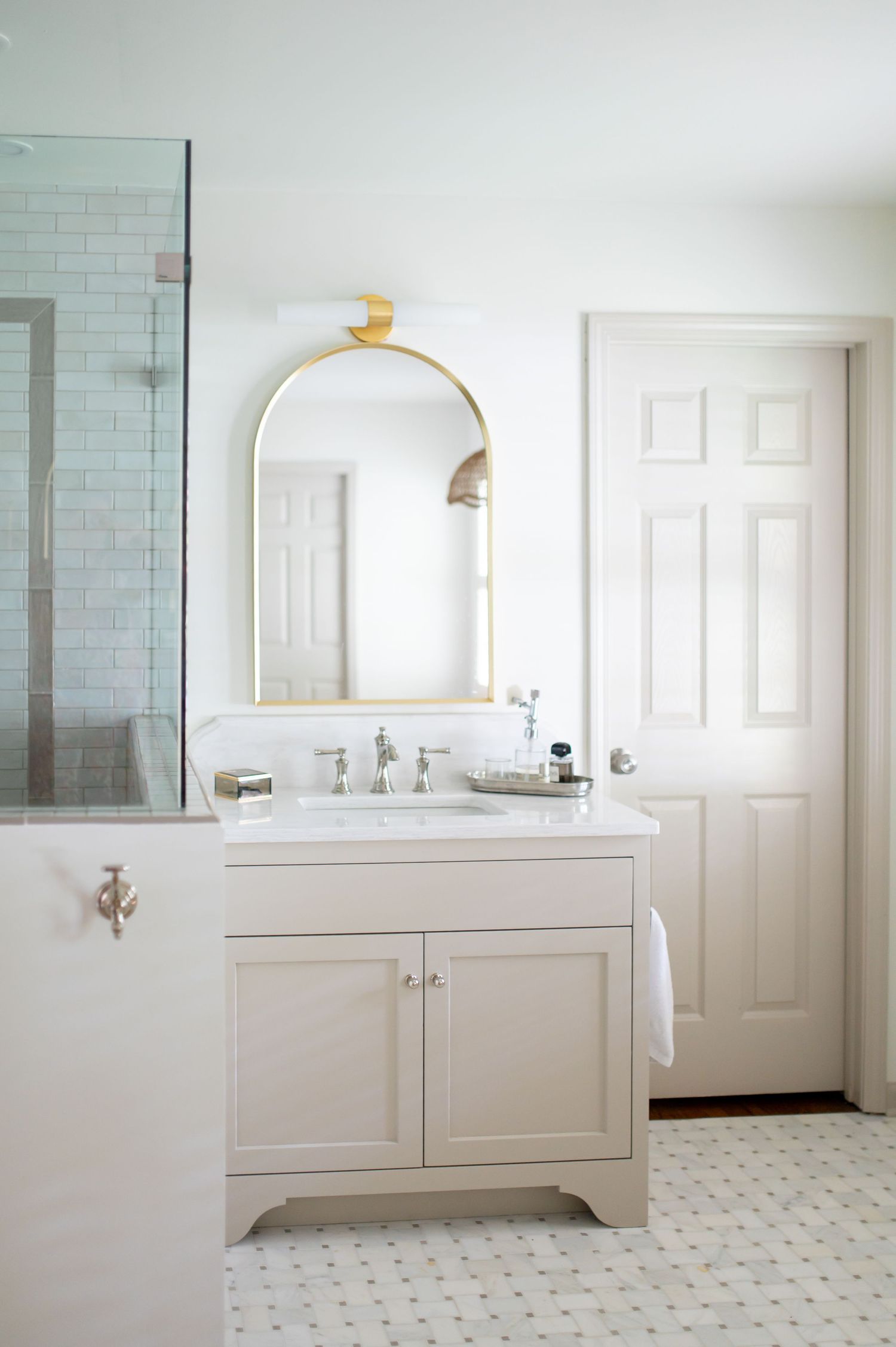 Bright white modern bathroom interior with subway tile walls, floating vanity, and minimalist design features.