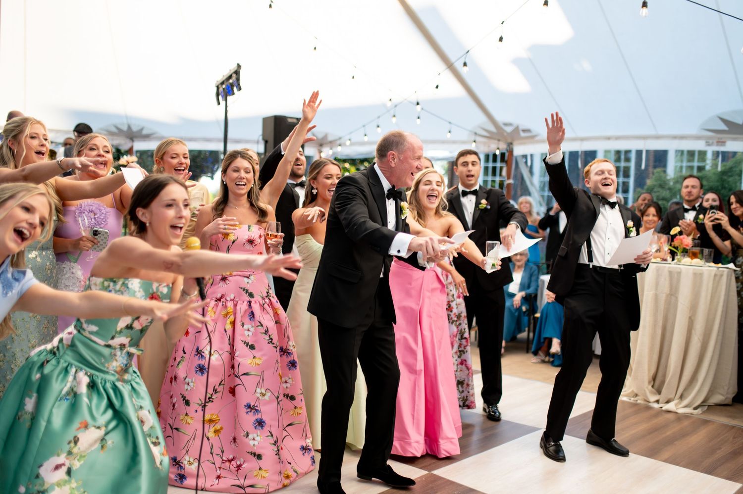 Energetic wedding reception dance floor with guests in colorful formal attire celebrating.