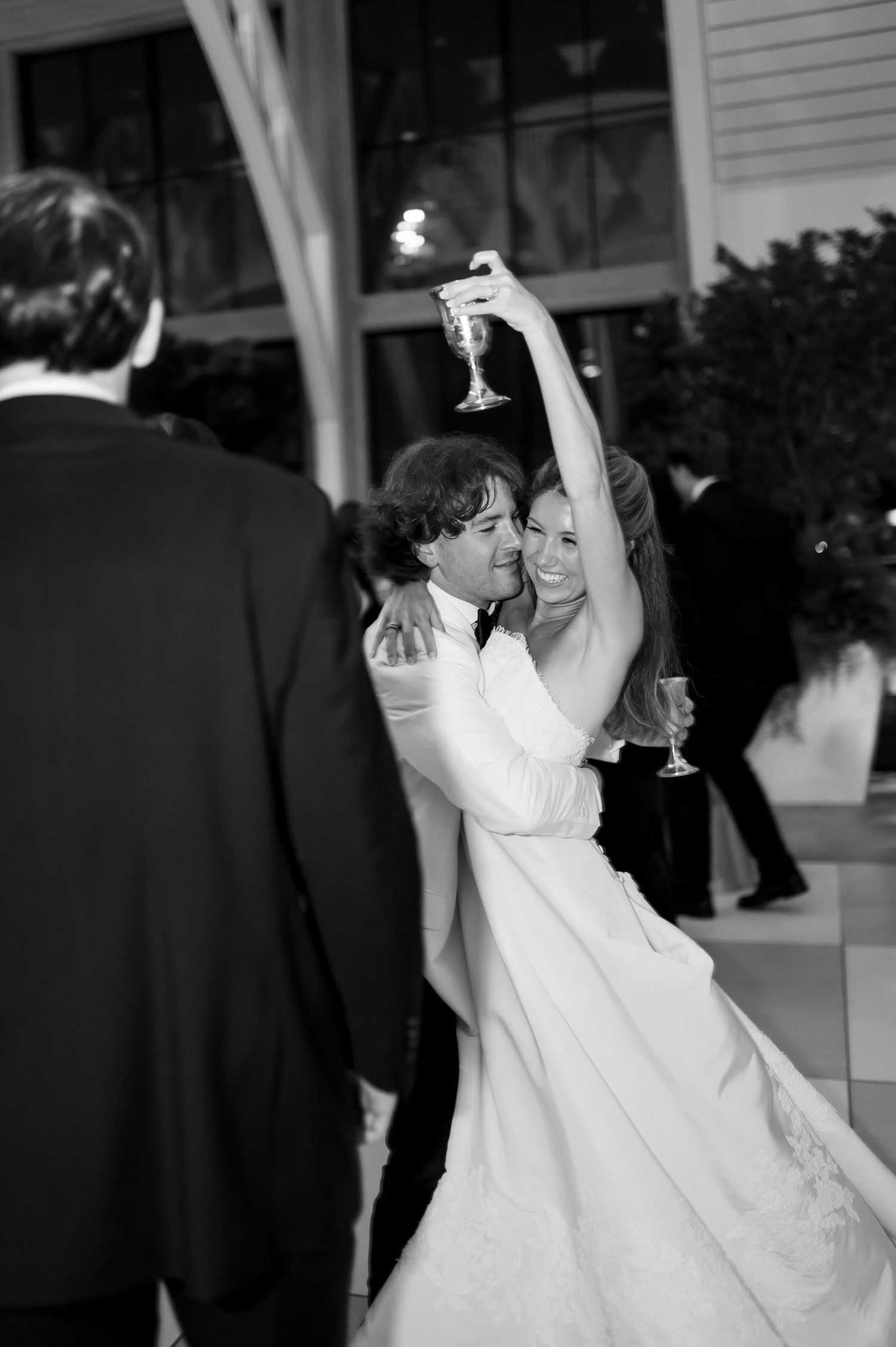 Black and white photo of a romantic dance with champagne glasses in hand.