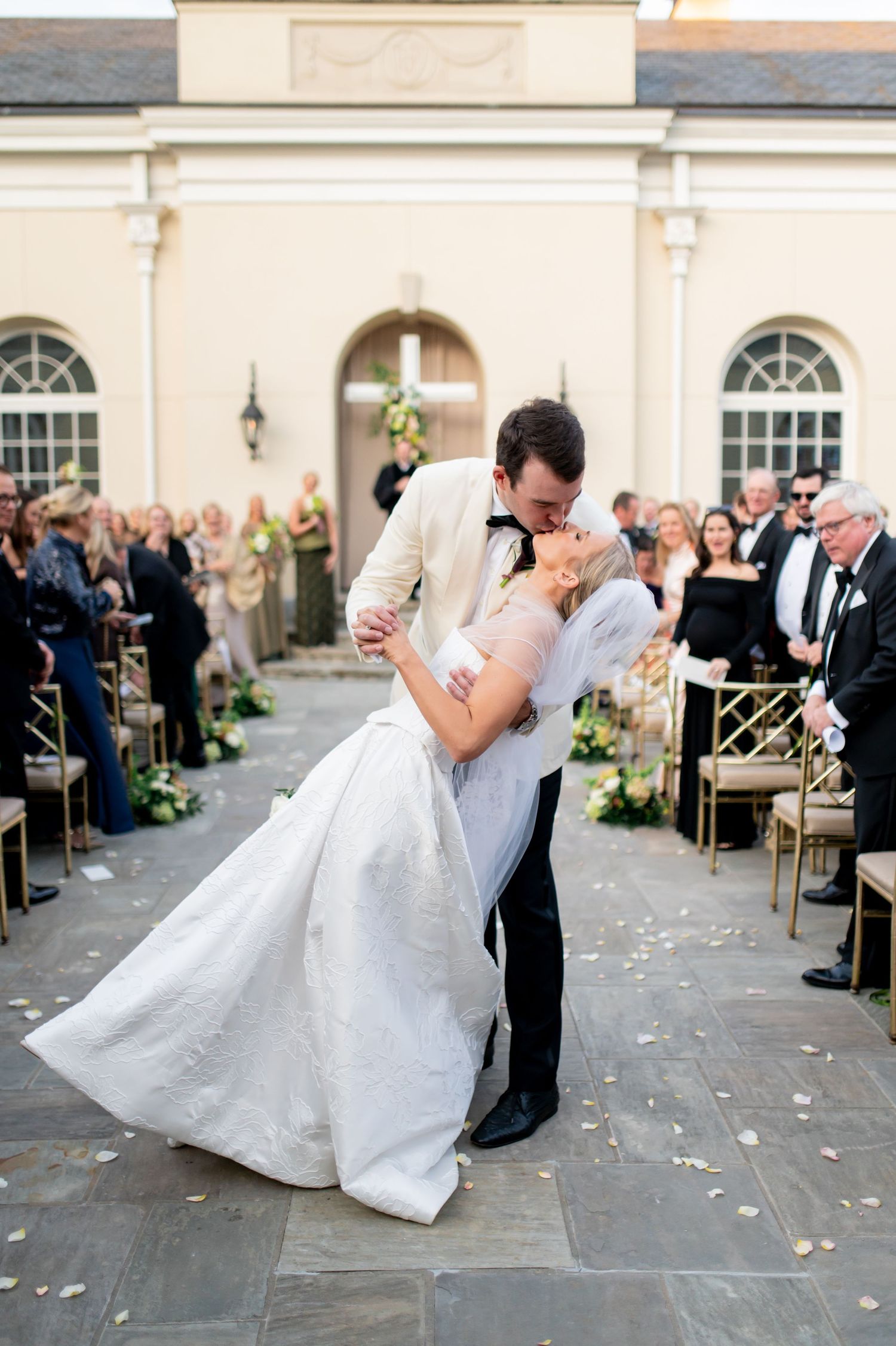 Romantic wedding dance sequence on an outdoor stone patio with scattered rose petals.